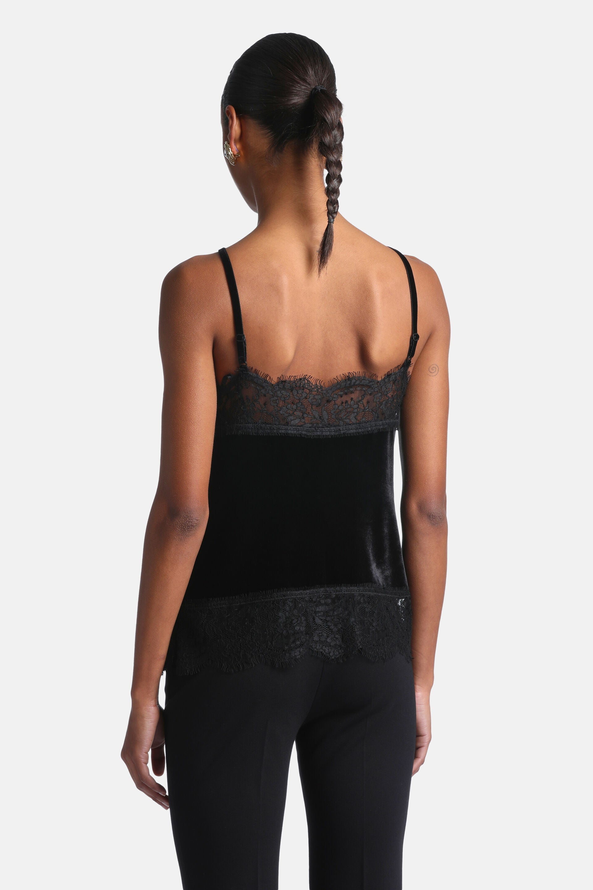 Black velvet camisole top with thin adjustable straps and scalloped black lace trim along the back neckline and hem.