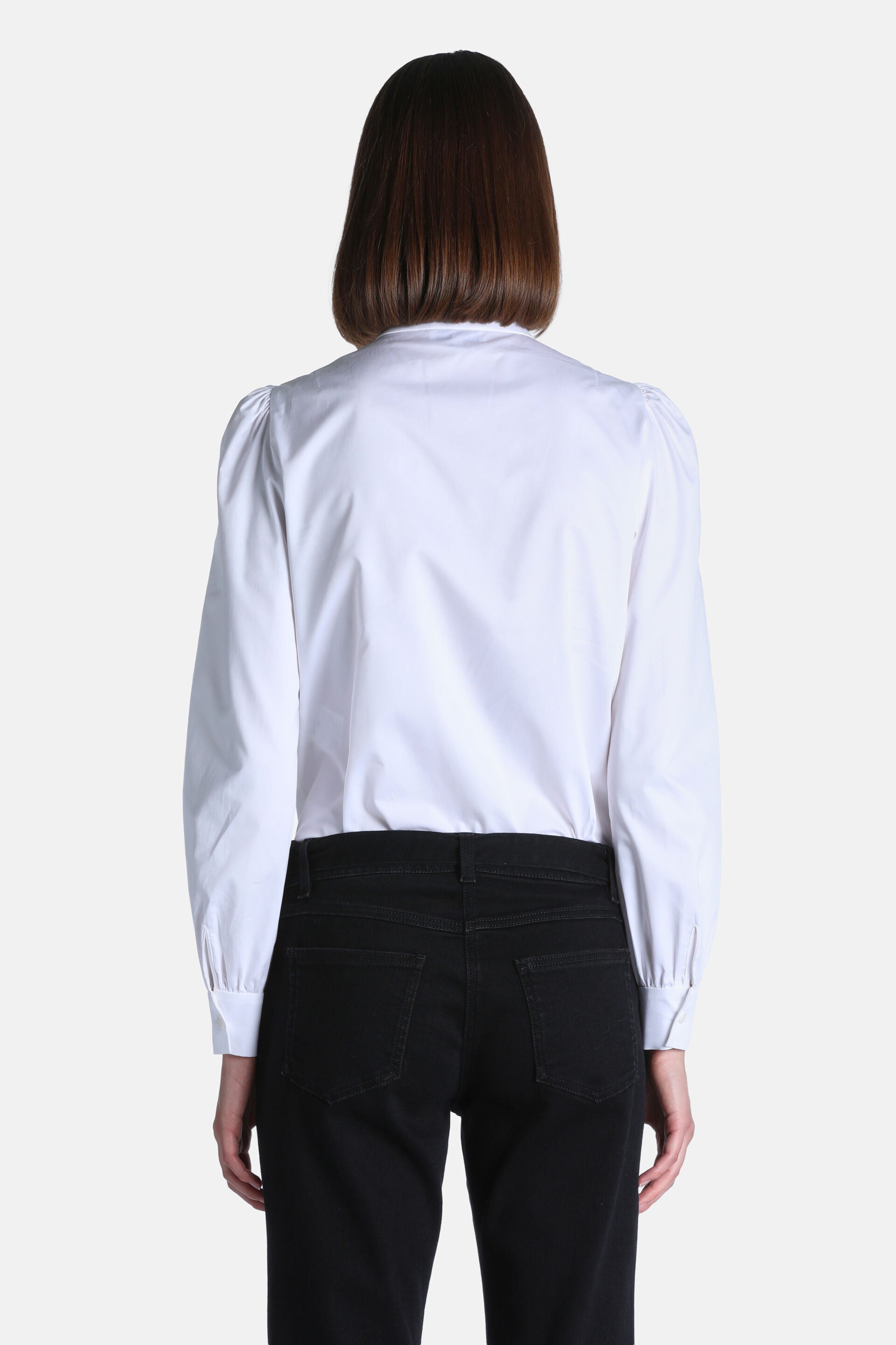 White long-sleeve shirt with a high neck, slightly puffed shoulders, and buttoned cuffs.