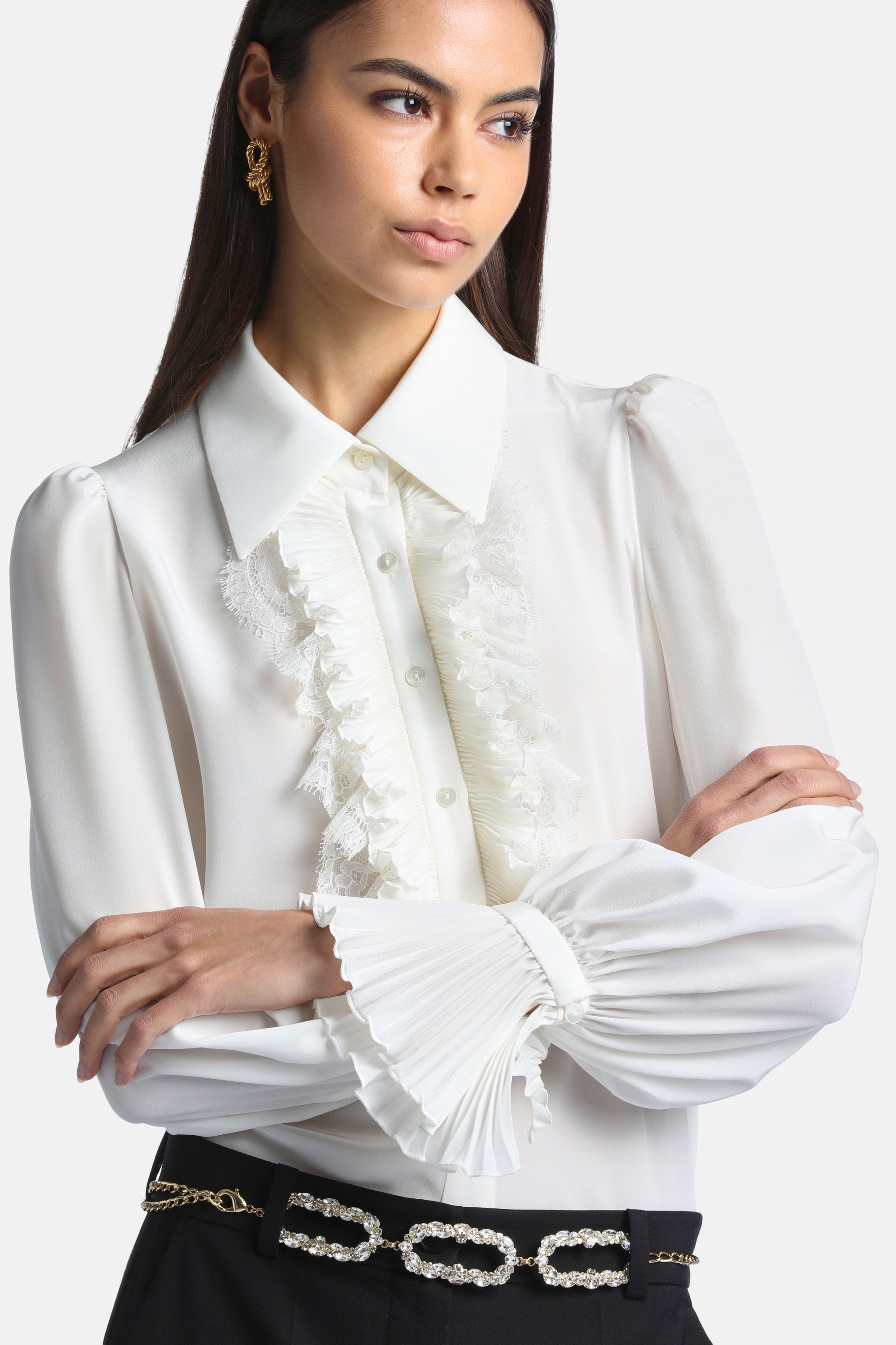 Ivory long-sleeve blouse with a pointed collar, ruffled and lace-trimmed placket, puffed shoulders, and wide pleated cuffs.