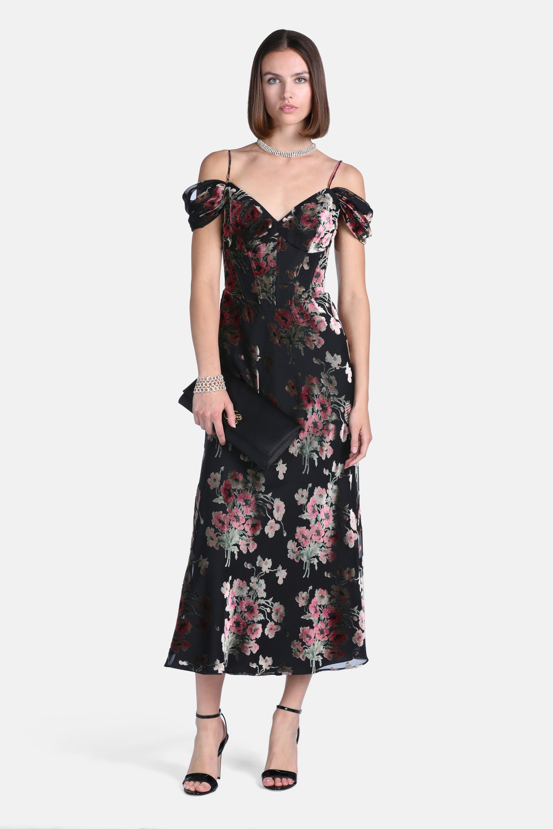 Black midi dress with pink and green velvet floral print, sweetheart neckline, spaghetti straps, and off-the-shoulder draped