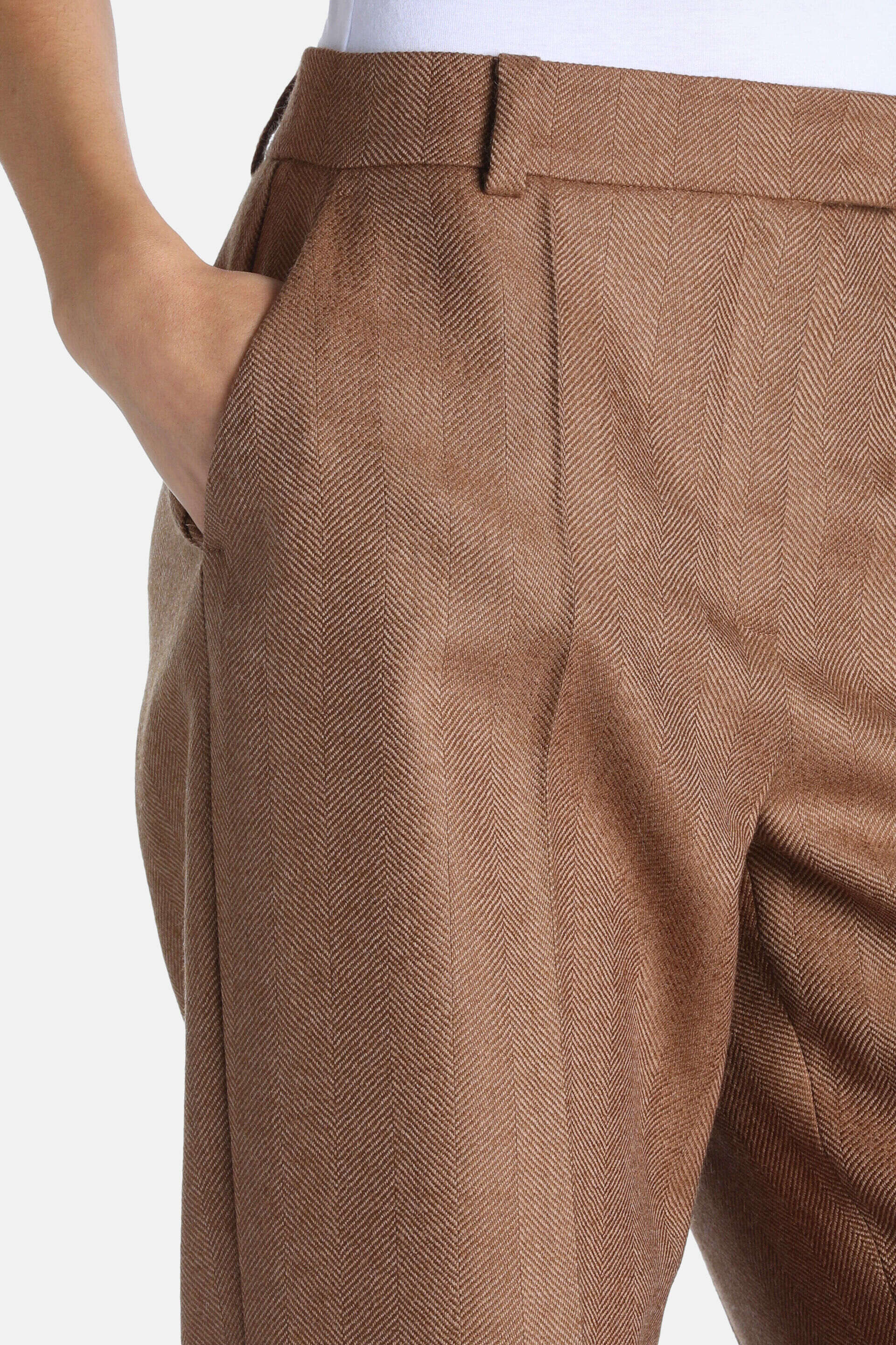 Brown herringbone trousers with belt loops, a side slash pocket, and front pleats.
