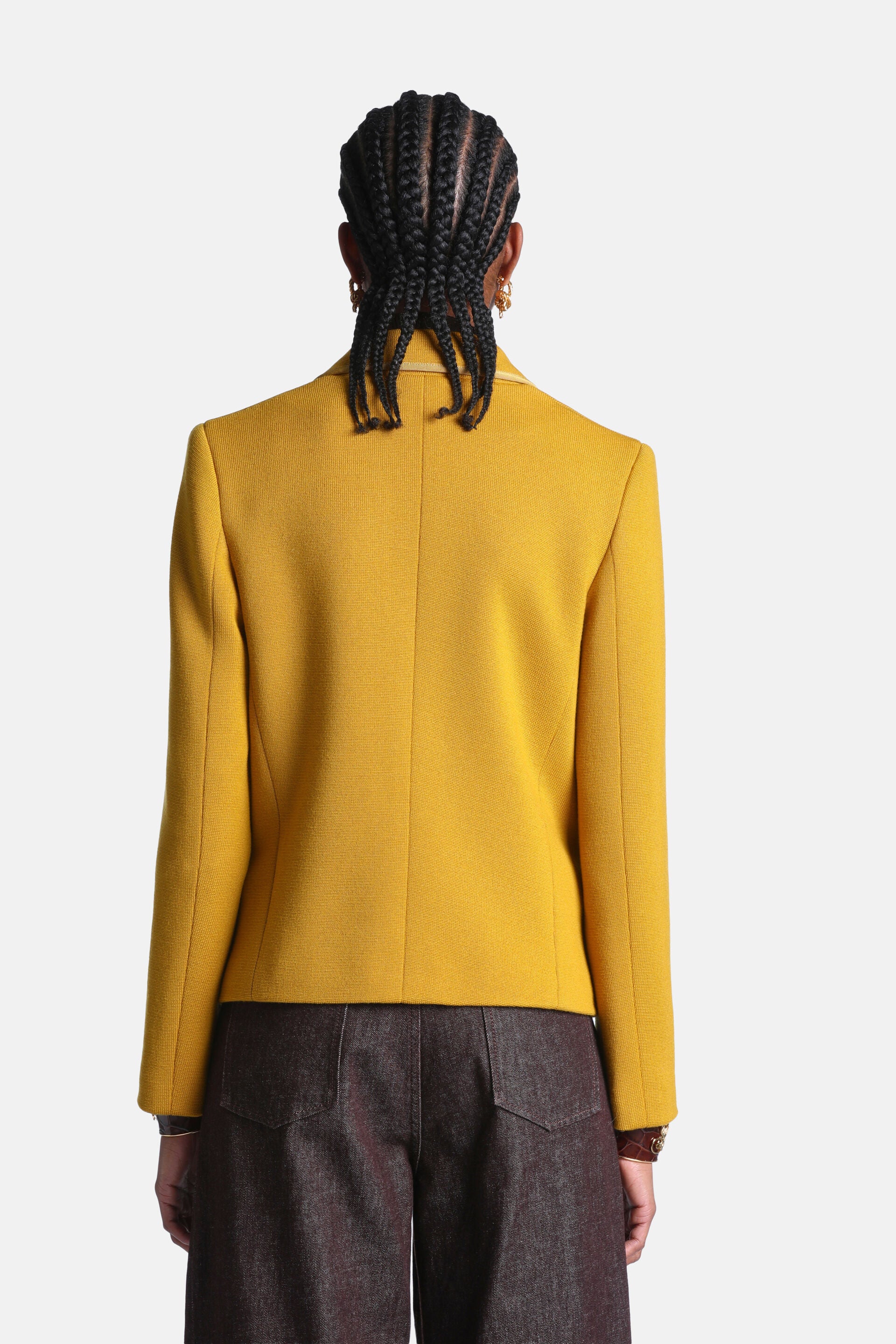 Mustard yellow tailored jacket with a moleskin-like texture, long sleeves, structured back, and a gold-toned inner collar.