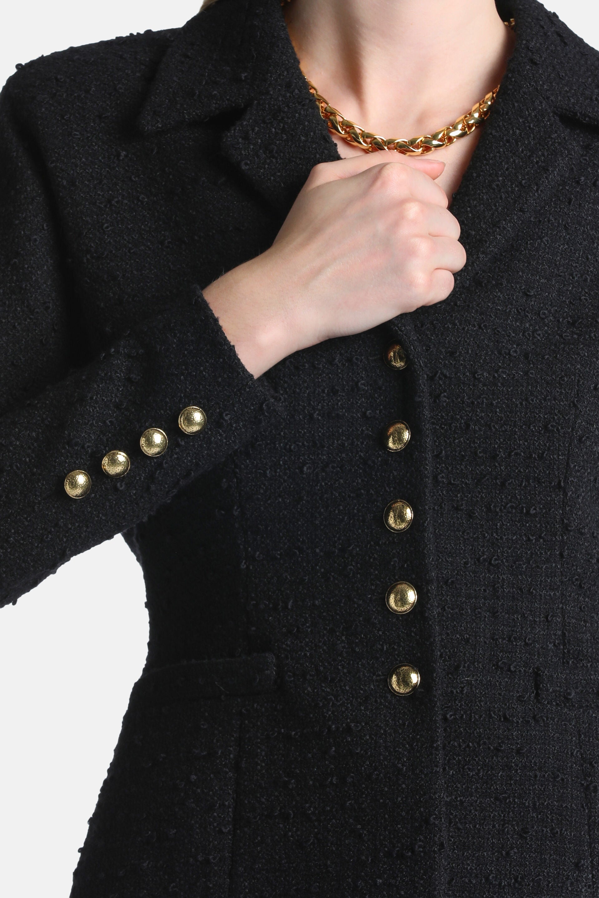 Black tweed jacket with notched lapels, five gold-toned buttons down the front, and four gold-toned buttons on the left cuff.