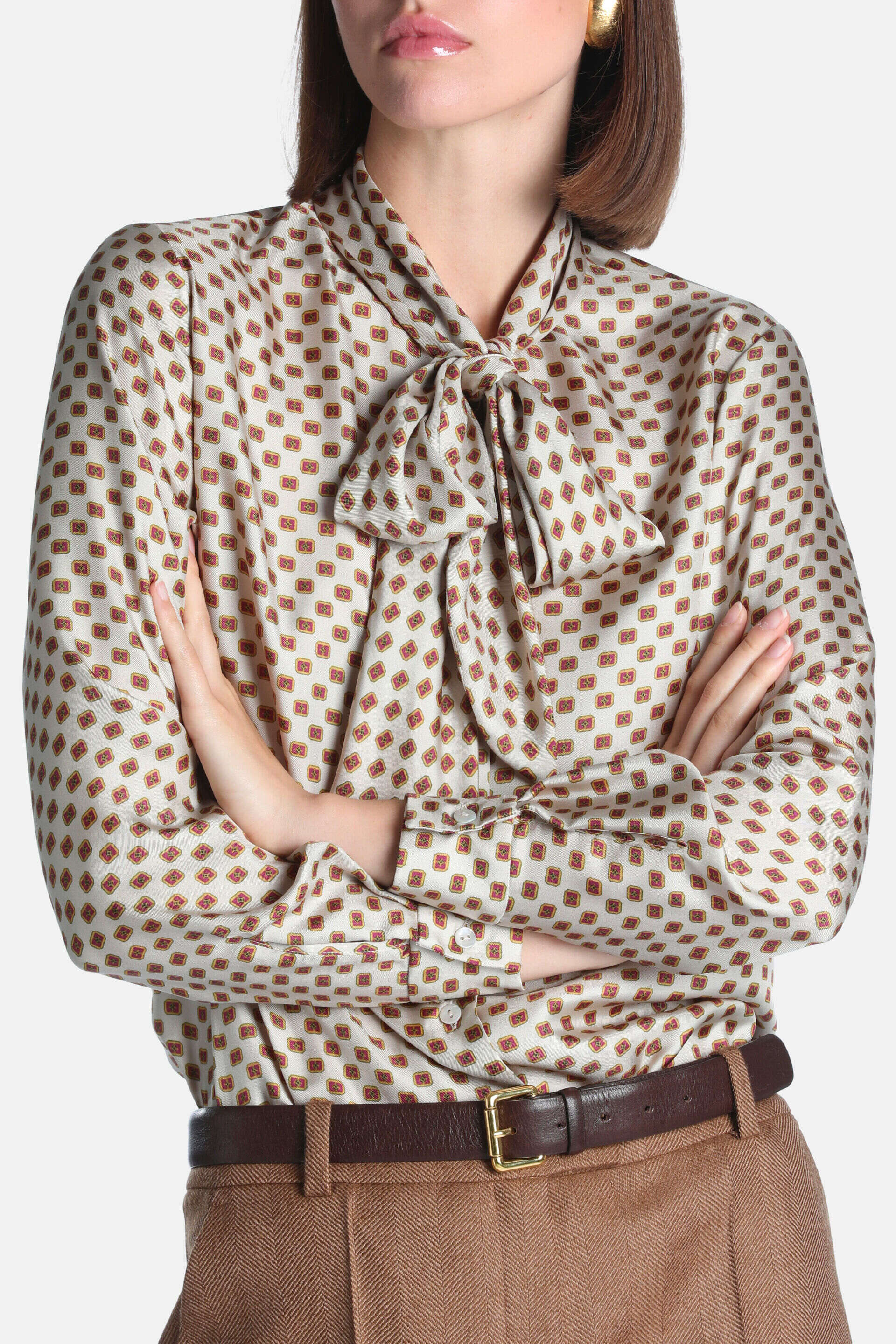 Cream silk shirt with a repeating red and orange geometric pattern, long sleeves with buttoned cuffs, and a pussy-bow tie at