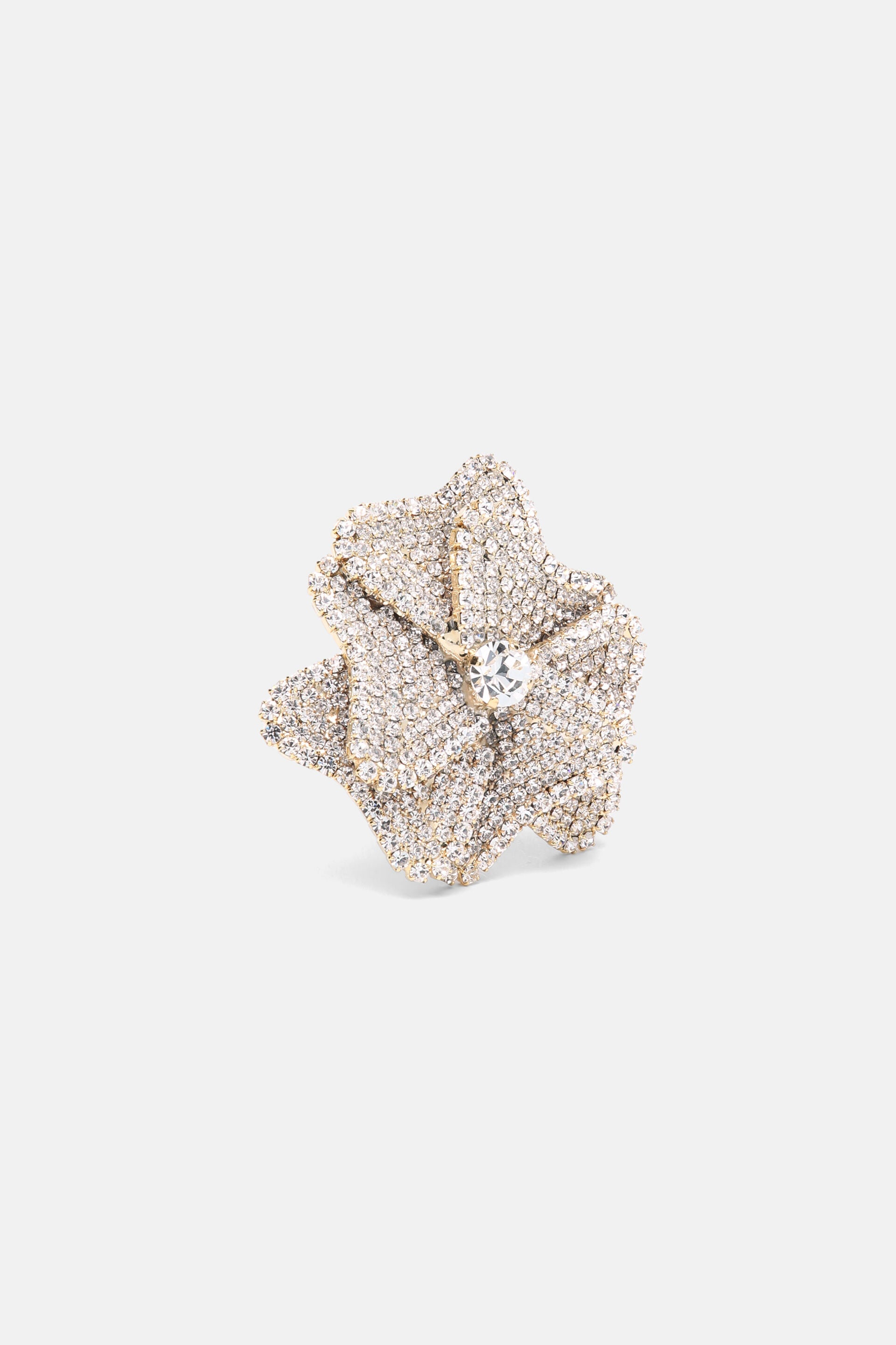 Gold-toned, multi-layered flower brooch covered in clear rhinestones, with a larger clear rhinestone at its center.