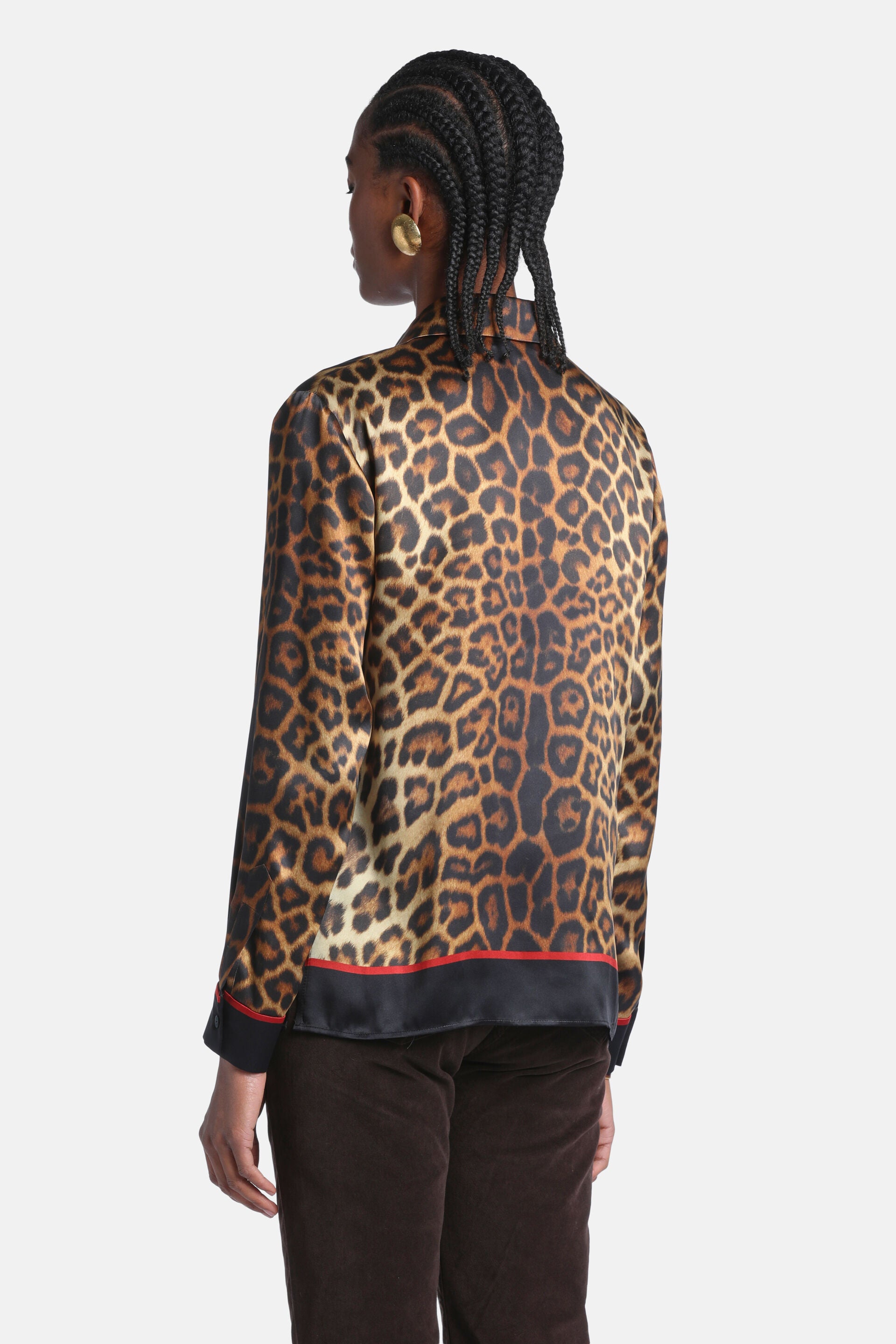 Silk leopard print shirt with long sleeves, a collar, and a black bottom hem with a red stripe.