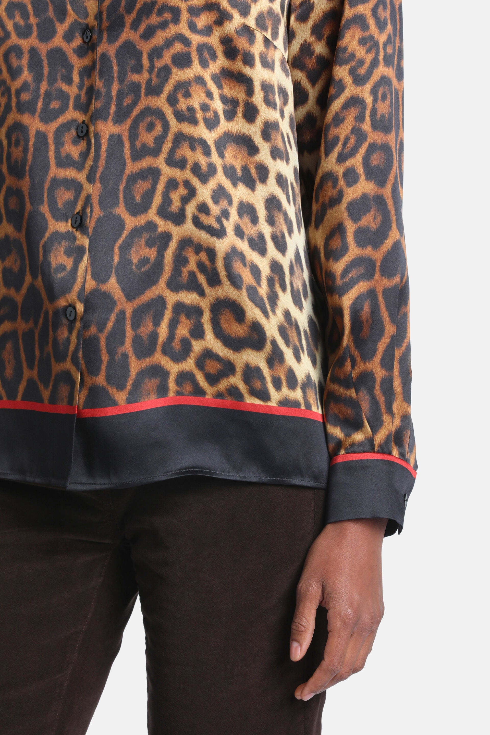 Leopard print silk shirt with black buttons, a black hem band with a red stripe, and matching cuffs.