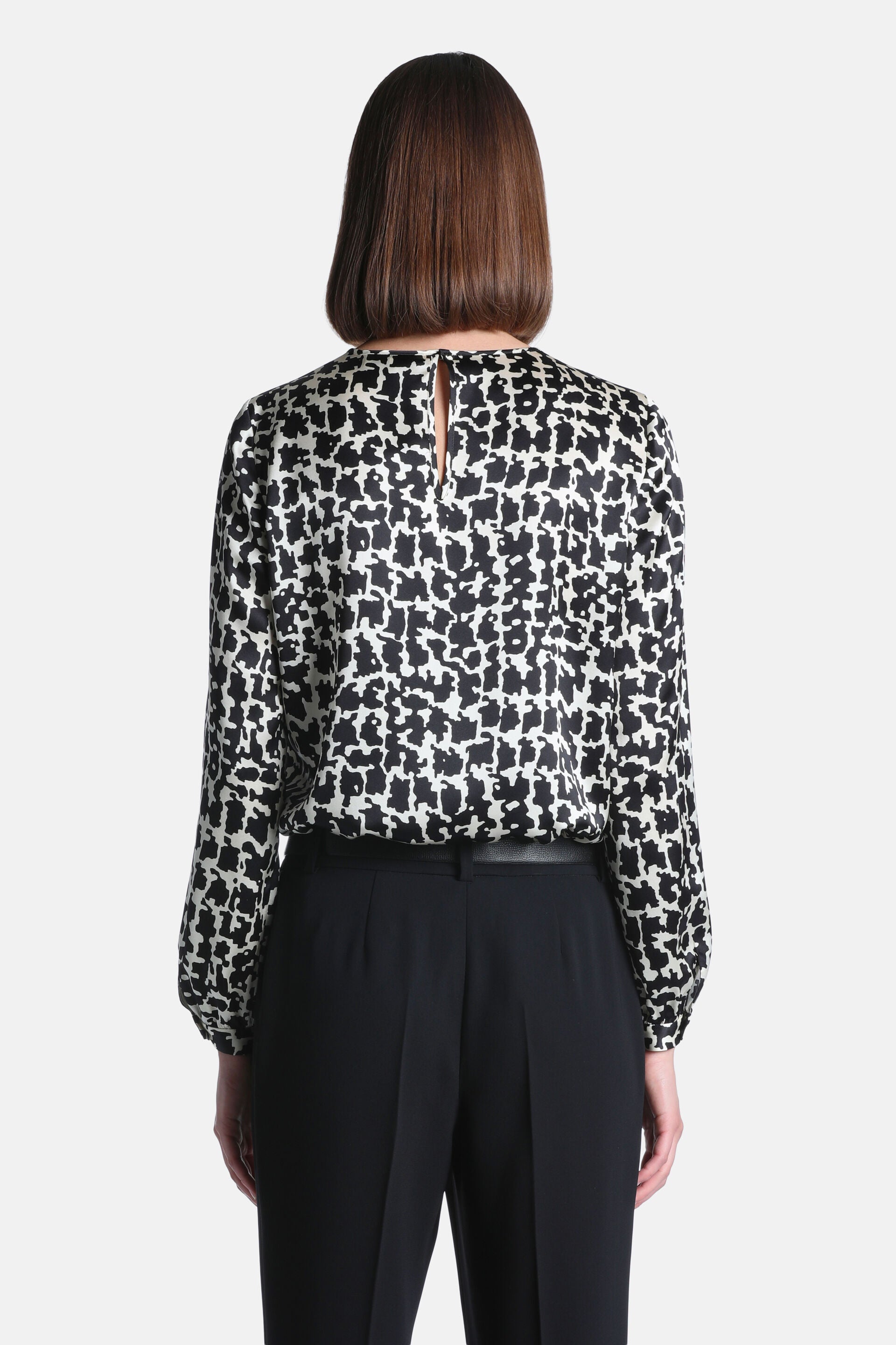 Black and cream abstract pattern long-sleeved shirt with gathered cuffs and a keyhole button closure at the back neck.