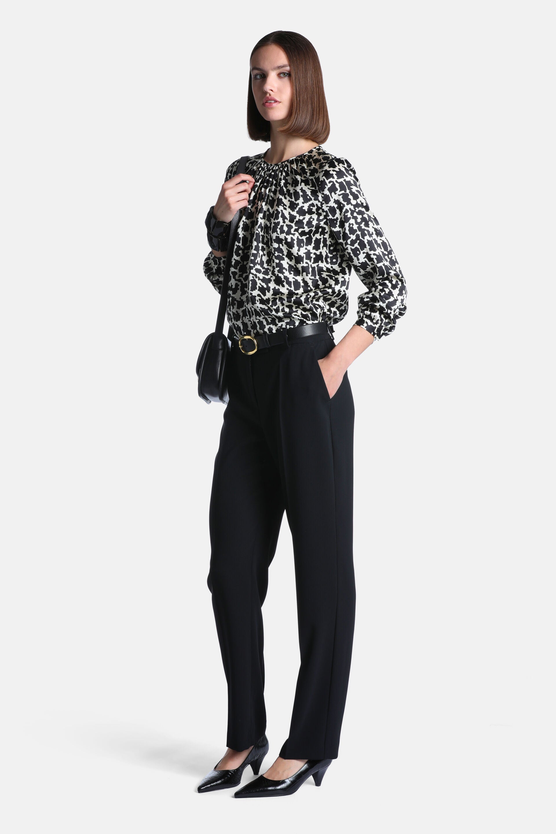Black and cream animal print blouse with a gathered round neckline and long, voluminous sleeves with gathered cuffs.