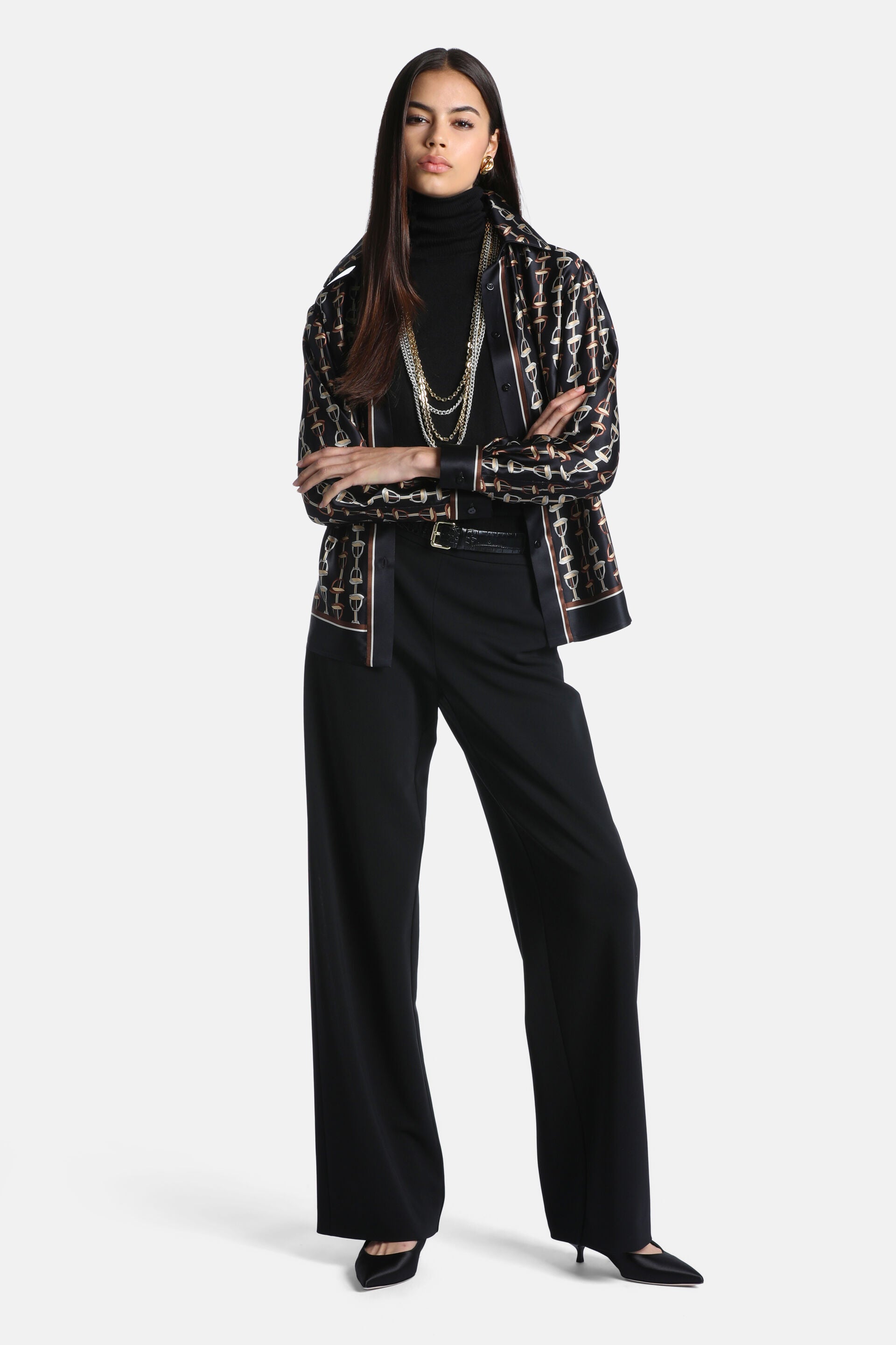 Black silk button-up shirt with gold-toned and brown equestrian chain print. Collared, long sleeves with black cuffs.
