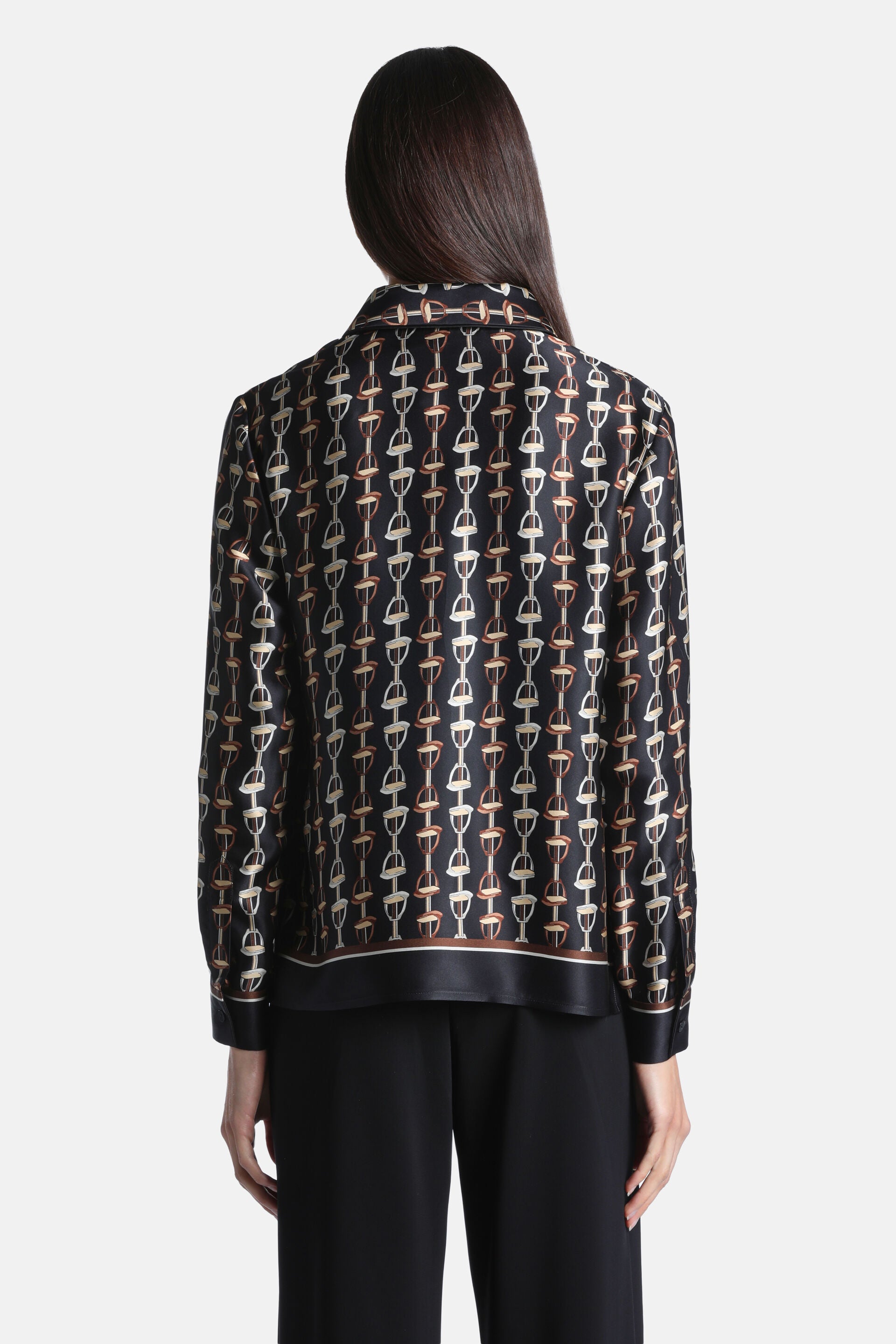 Black silk shirt with all-over light beige and brown equestrian bit print. Collared, long-sleeved, with a striped hem band.