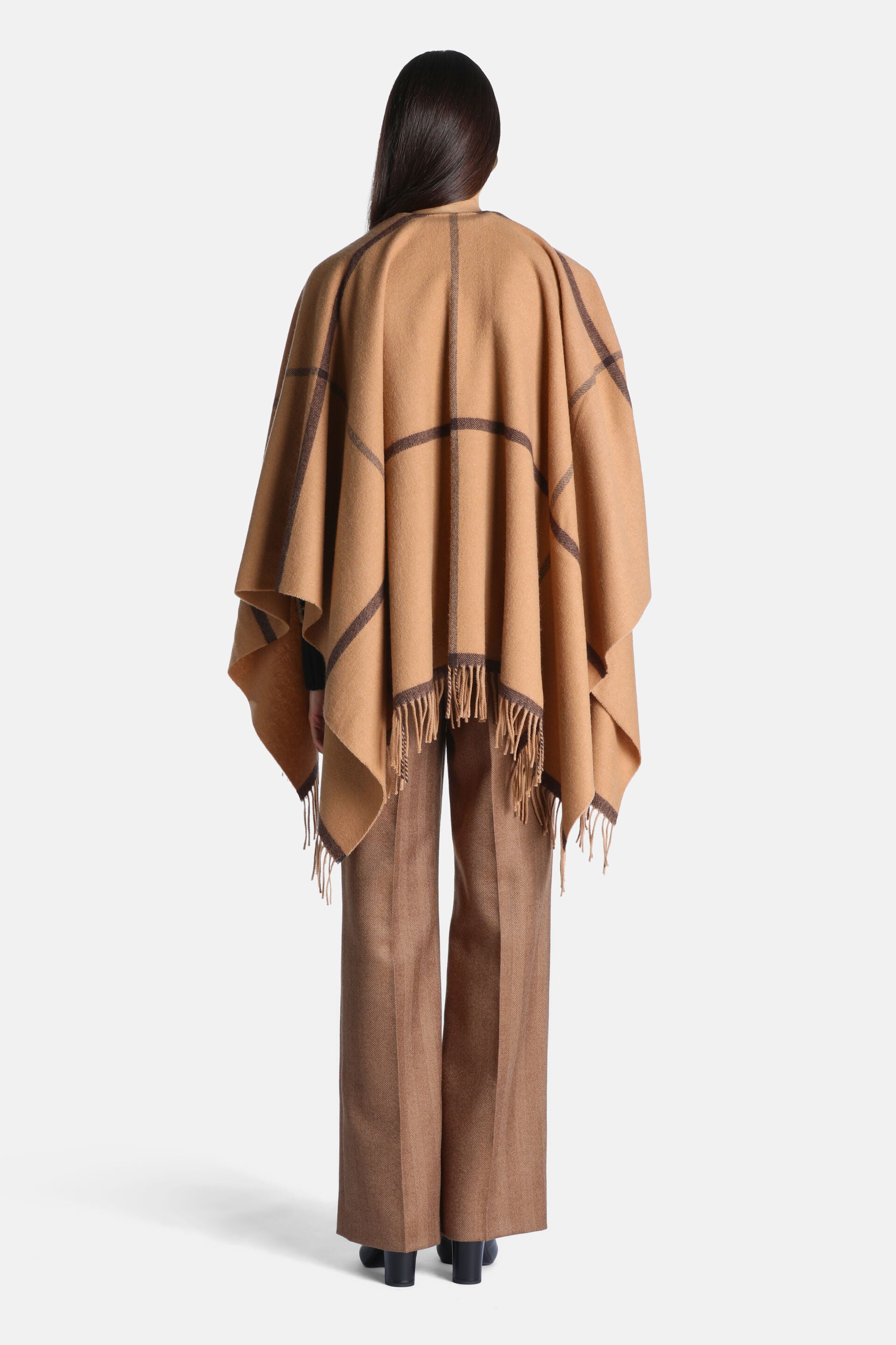 Camel fabric cape with a dark brown grid pattern and fringed hem.
