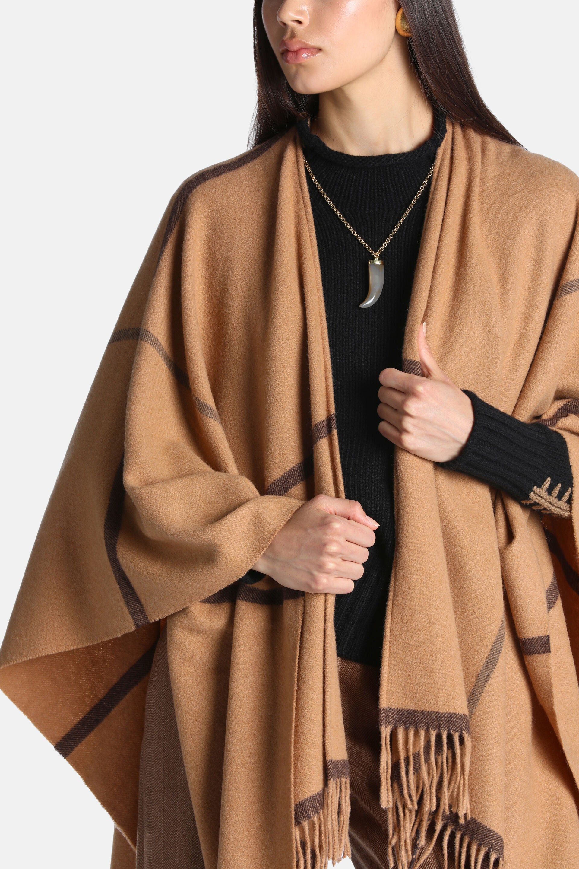Camel cape with dark brown geometric patterns and a fringed hem.