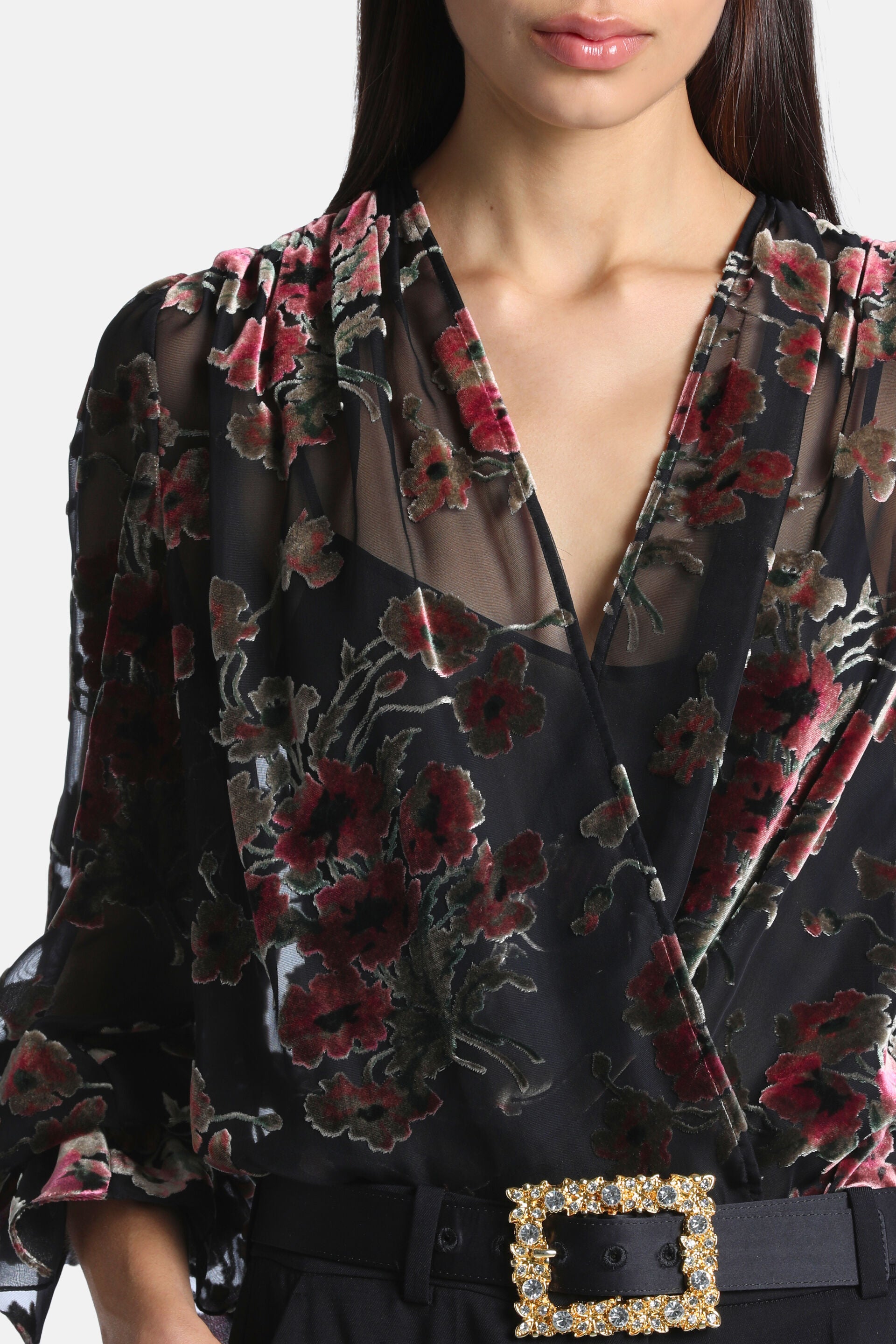 Black sheer shirt with pink and red velvet floral patterns, V-neck, wrap front, and ruffled cuffs.