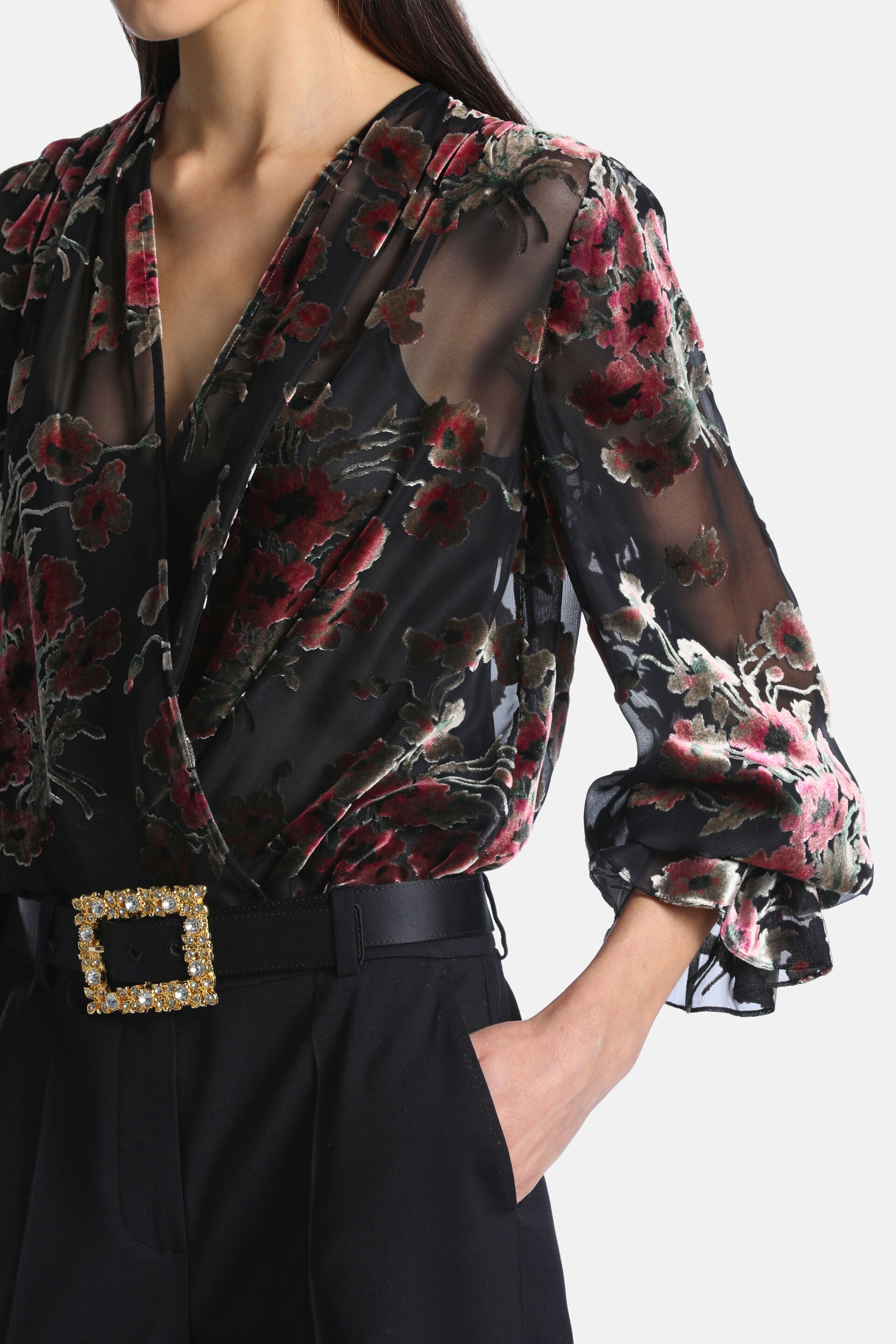 Black sheer wrap shirt with pink and red velvet floral pattern and gathered long sleeves.