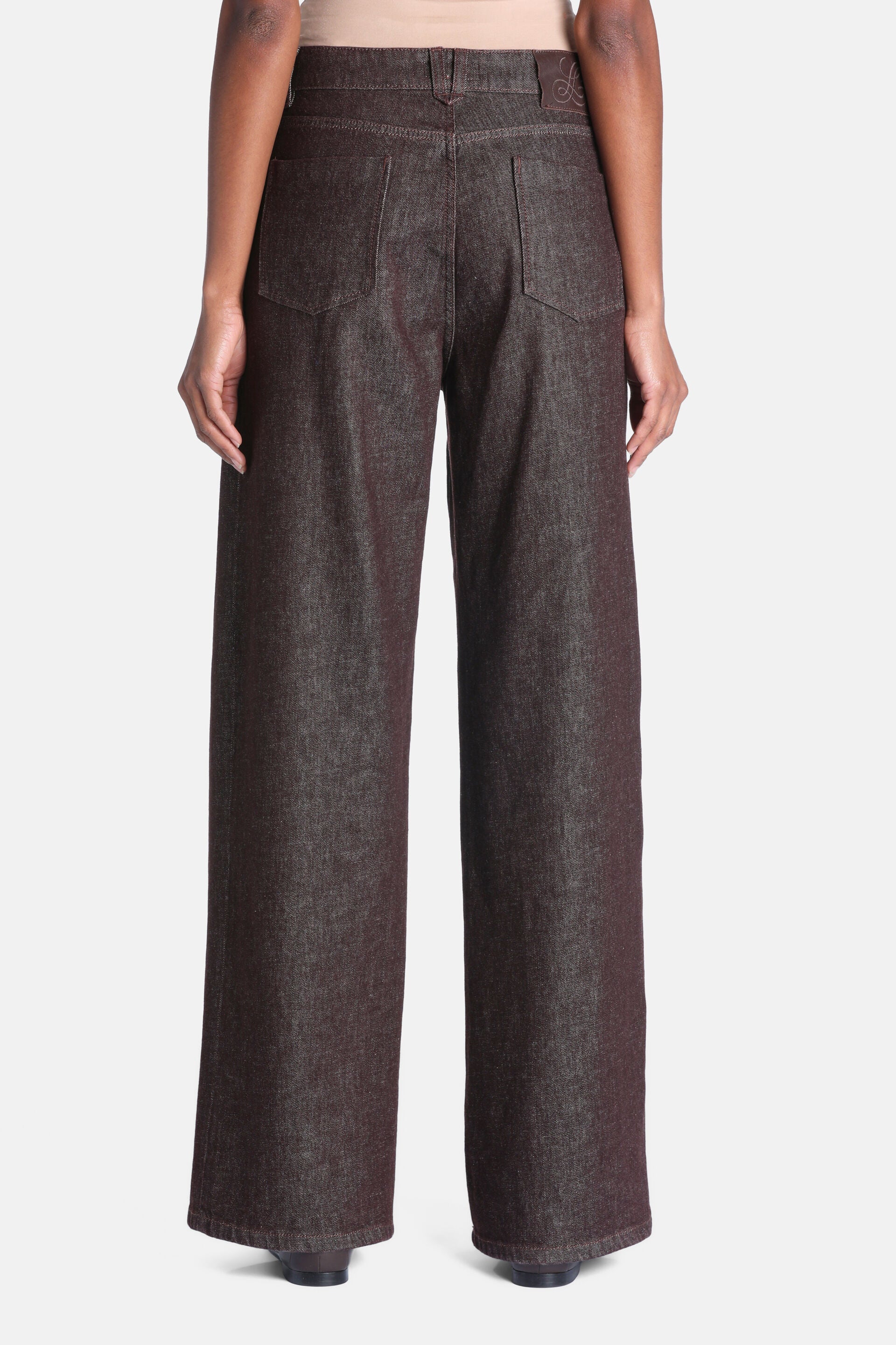 Dark brown textured wide-leg trousers with two back patch pockets and an embossed logo patch on the right side of the waistba