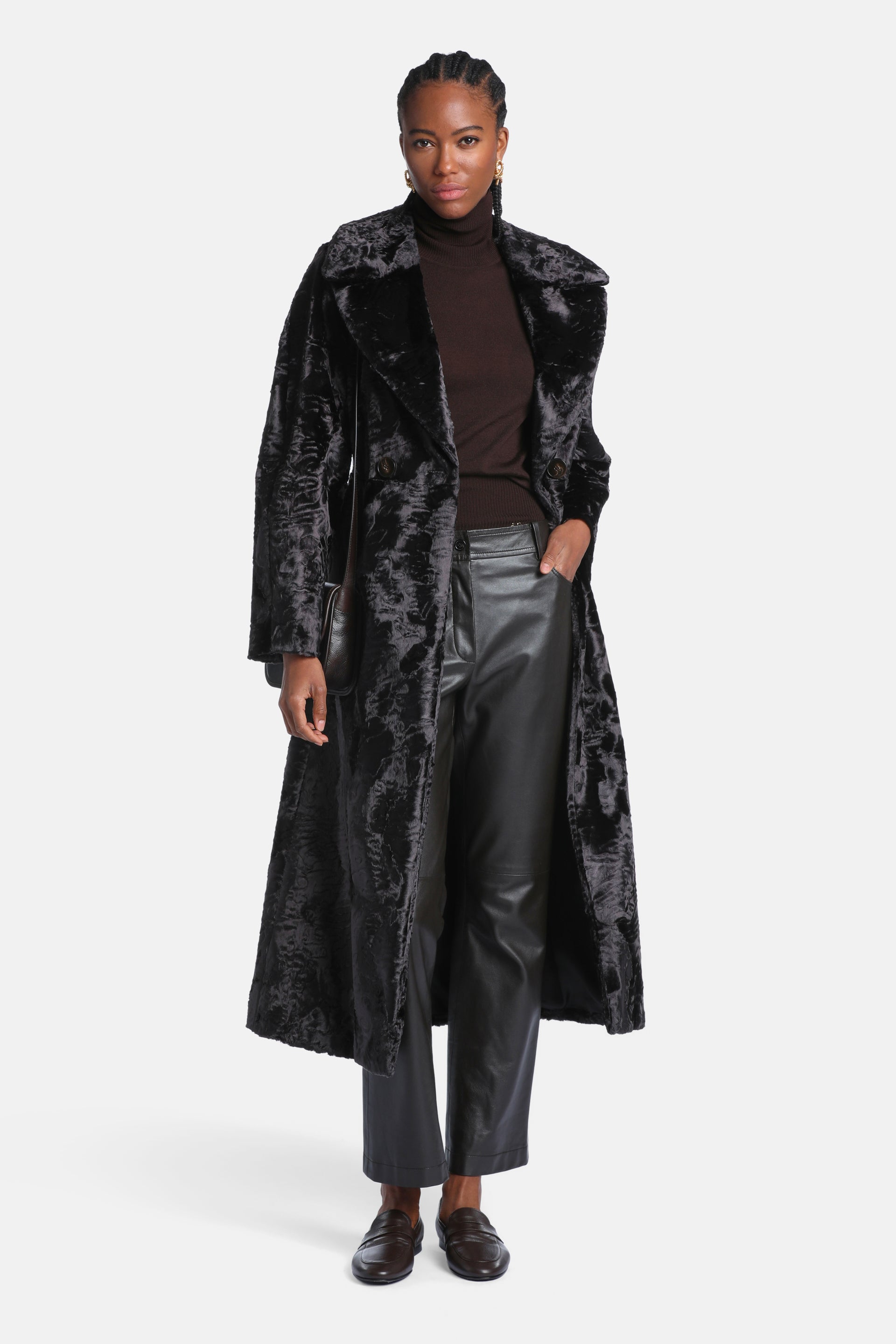 Long black coat with a curly, textured faux fur appearance, wide lapel collar, and two visible dark buttons.