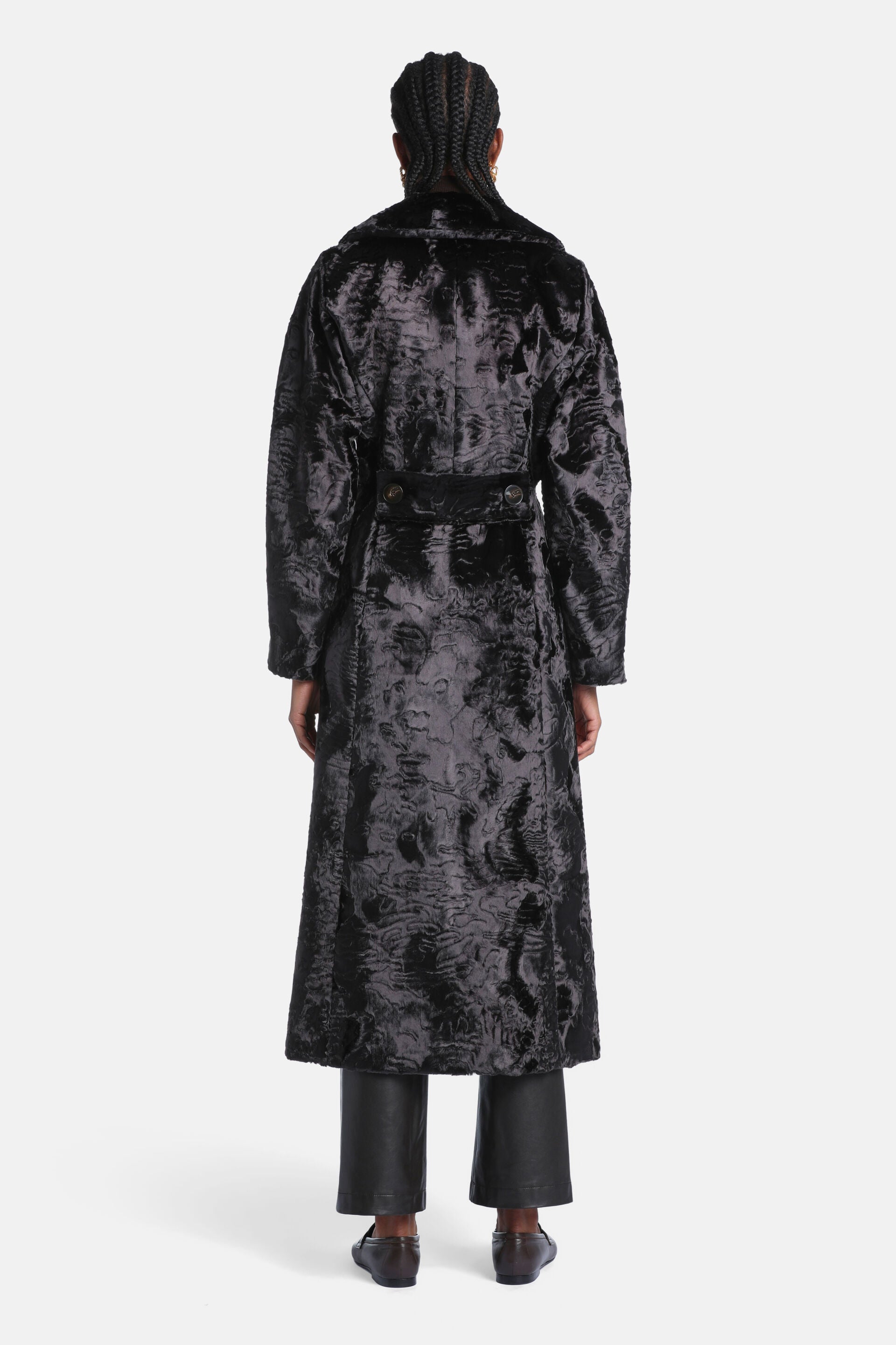 Long black faux fur coat with a textured, curly pattern. Features a collar and a belt at the back with two buttons.