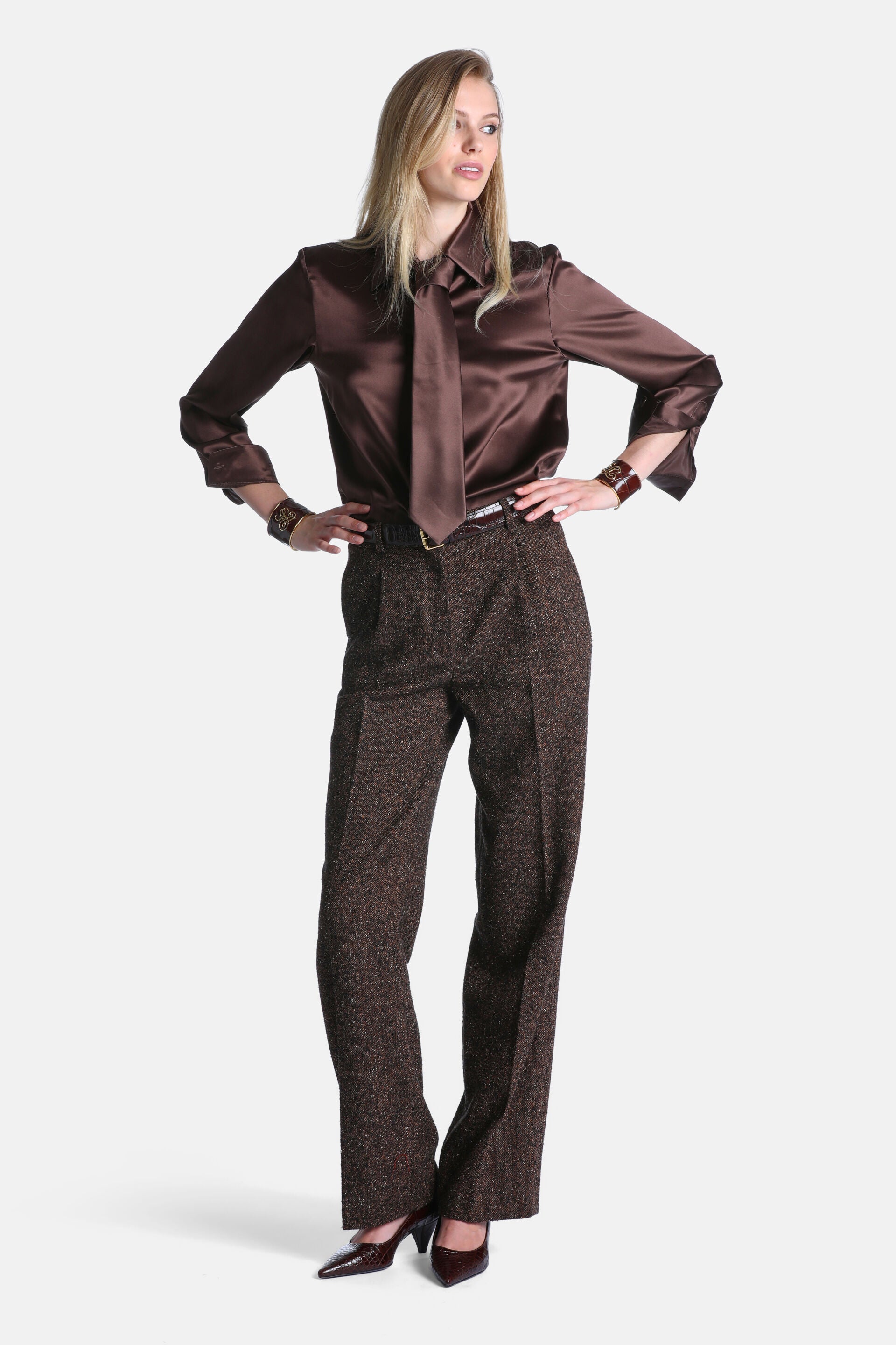 Brown tweed-like trousers with a speckled texture, high waist, and front pleats. Relaxed, straight-leg fit.