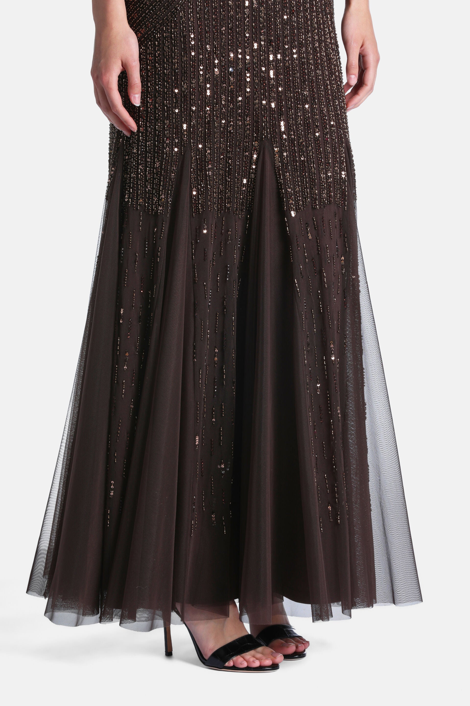 Dark brown mermaid-style dress. Upper skirt is heavily beaded and sequined, transitioning to a flowing sheer tulle skirt.