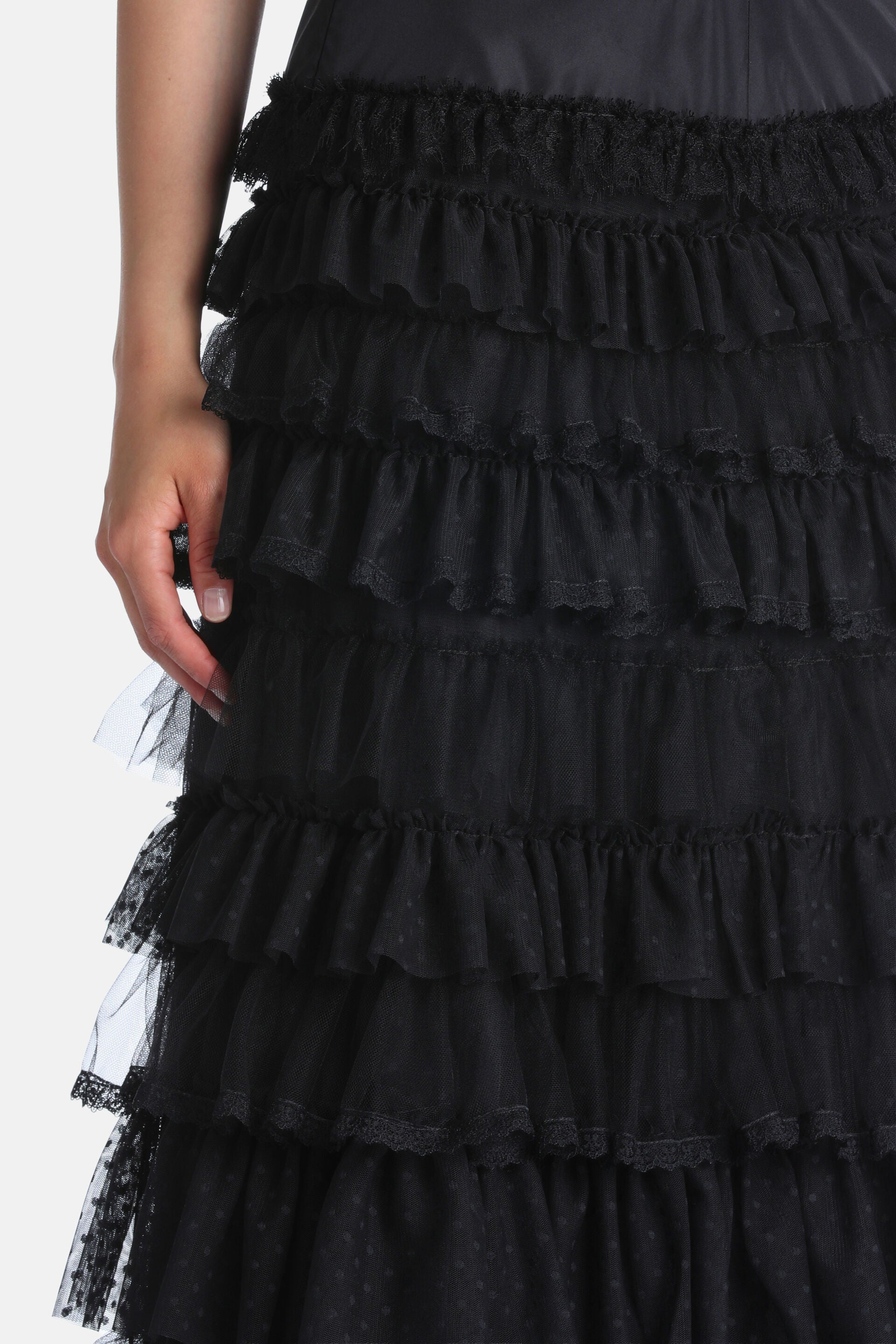 Black tiered skirt with multiple layers of gathered sheer tulle ruffles. Some ruffles feature subtle polka dots.