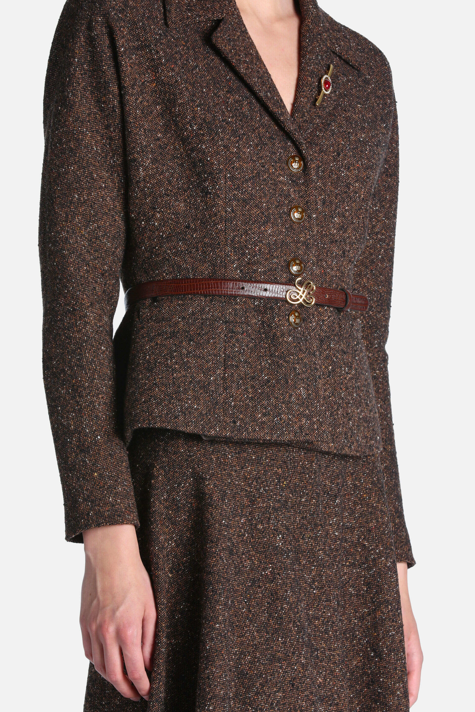 Brown tweed blazer jacket with notched lapels, long sleeves, and three round brown buttons with gold-toned rims.