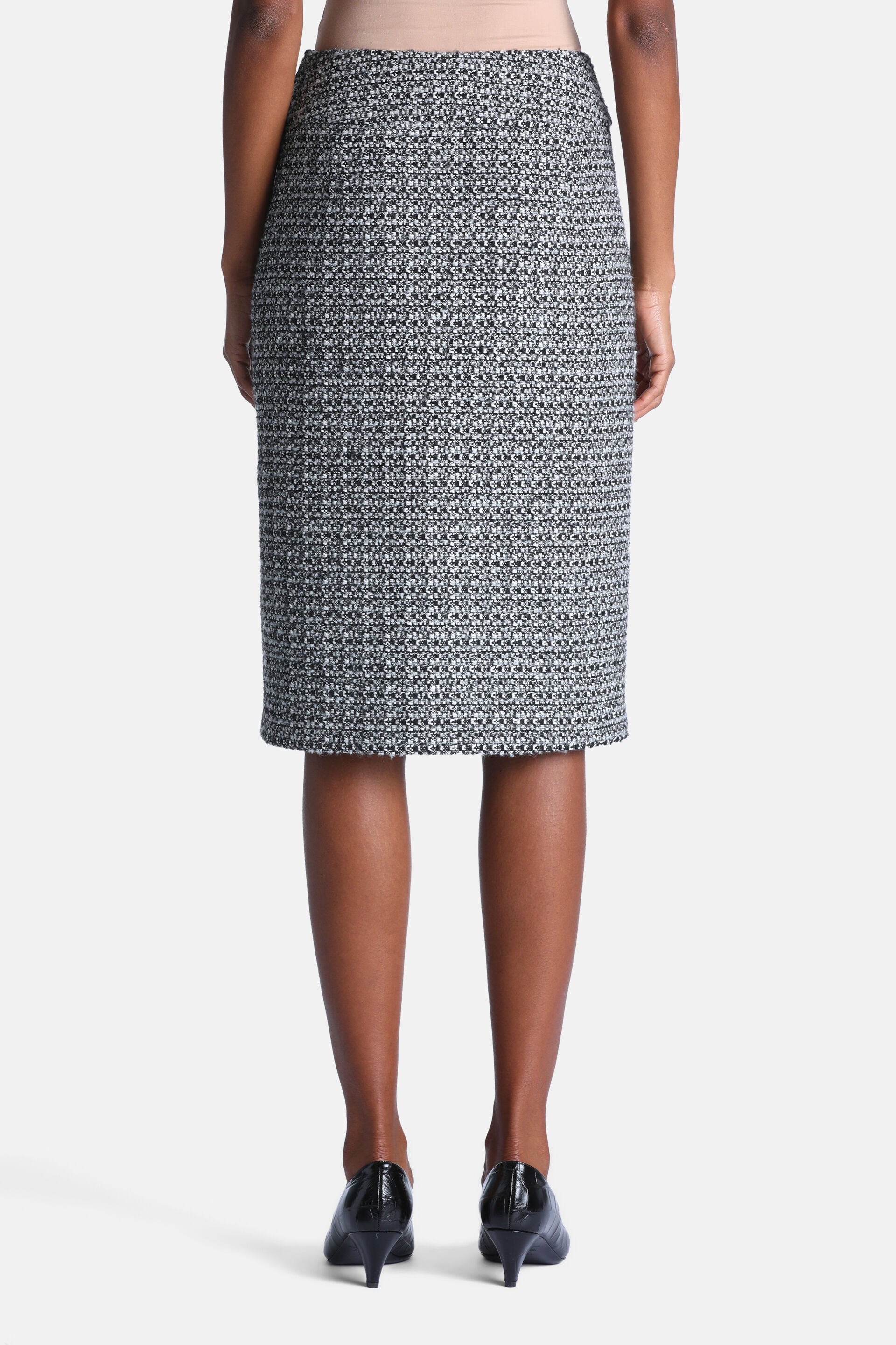 Knee-length pencil skirt in black and cream speckled tweed fabric with a straight hem.