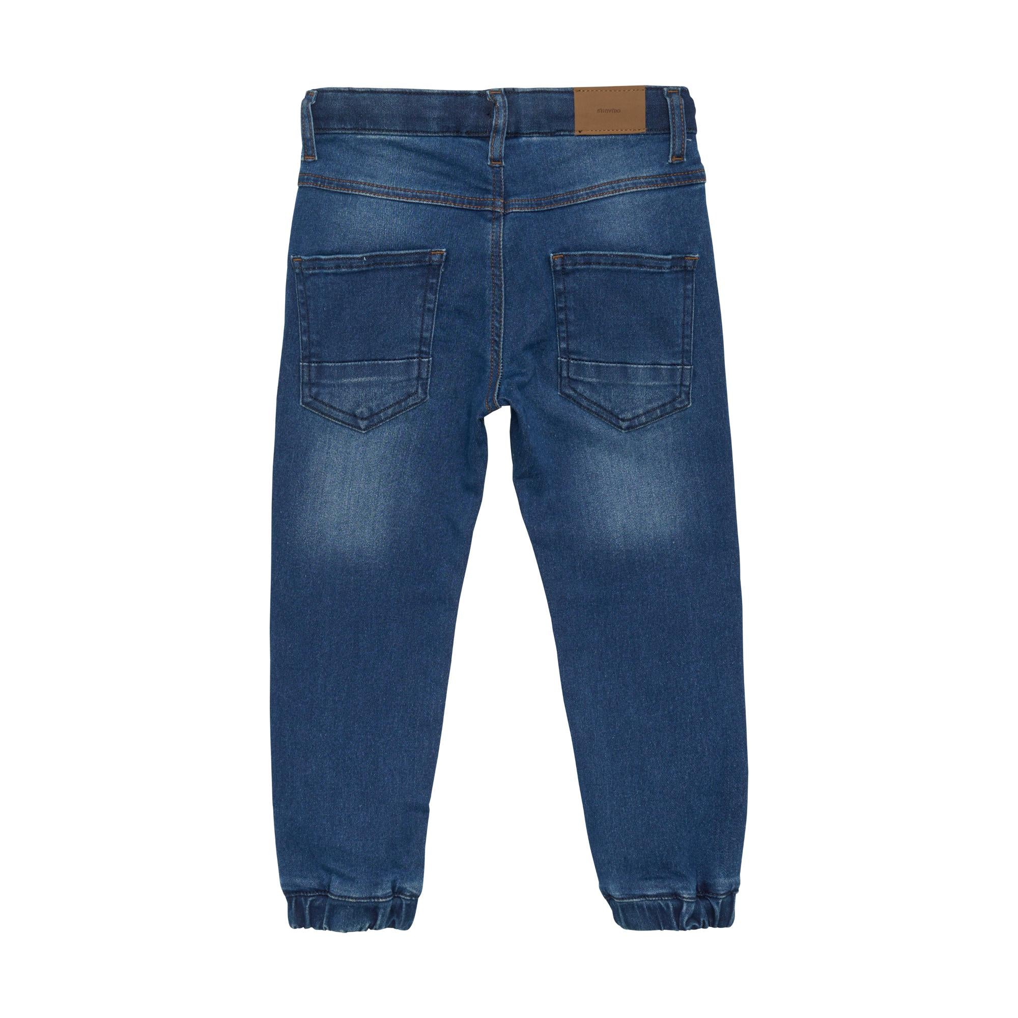 Back view of blue denim loose fit jogger jeans with faded areas, two back pockets with horizontal stitching, and a brown patc