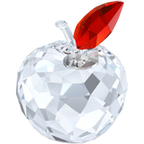 Clear faceted crystal apple figurine with a clear stem, a red faceted leaf, and a silver-toned disc engraved with 'NY'.