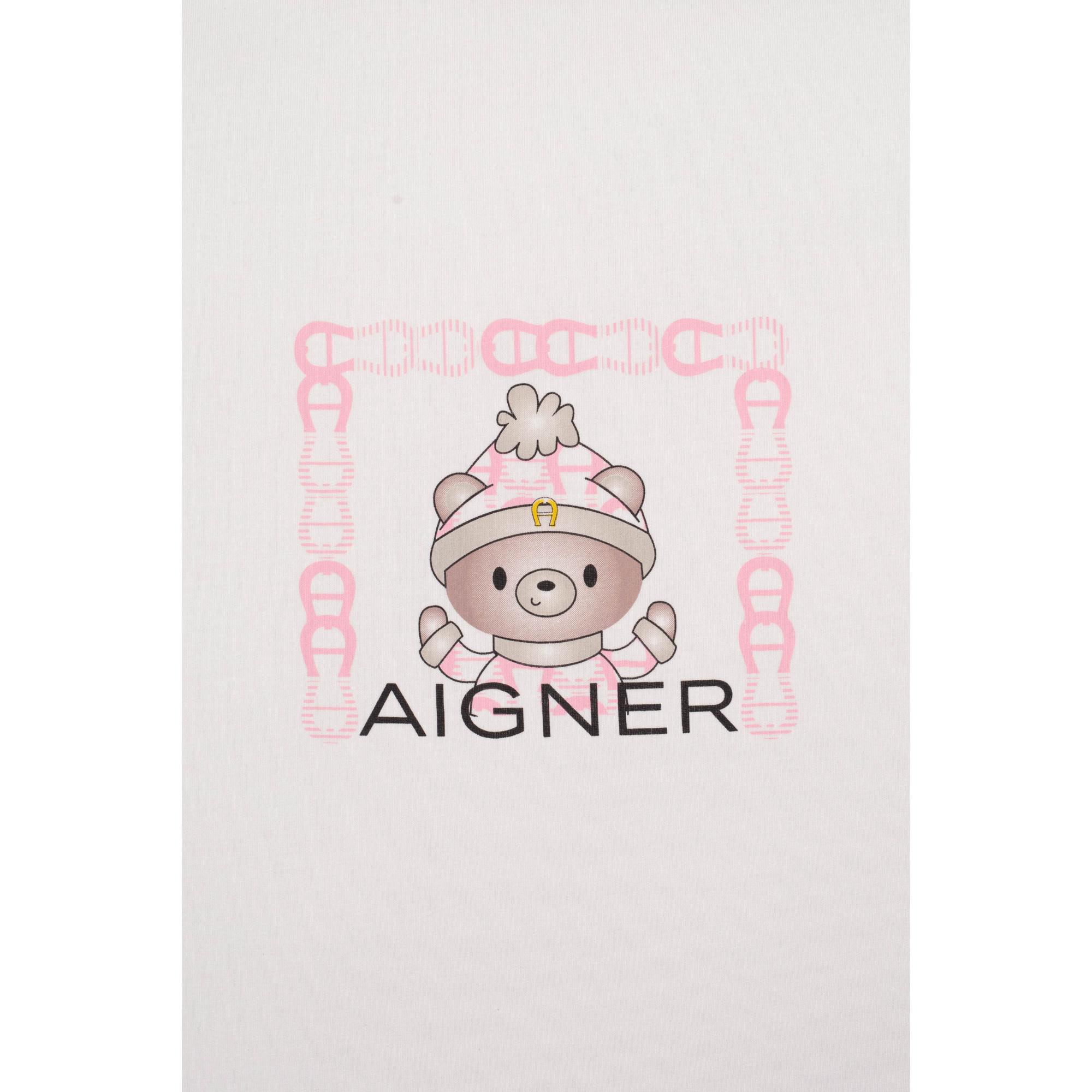 White fabric with a cartoon bear wearing a pink and white striped hat with a gold-toned horseshoe, framed by pink "A" logos.