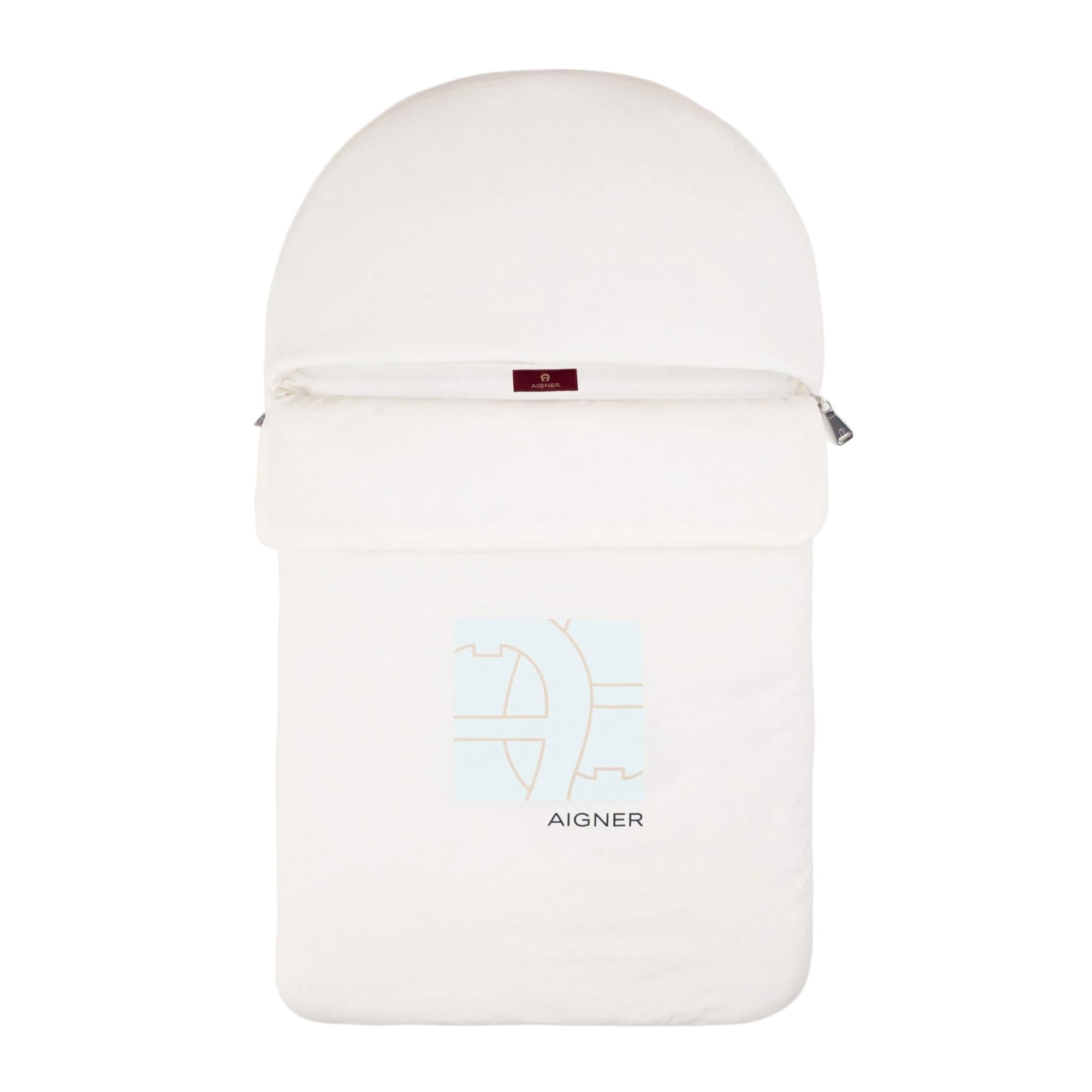 A beige padded baby nest with a rounded hood, a full-length zipper, and a light blue and tan Aigner logo on the front.