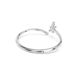Silver-toned open bangle with a smooth band. One end has a crystal-studded band leading to a crystal dragonfly motif.