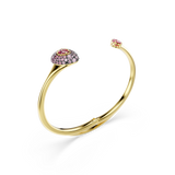 Gold-toned open bangle. One end has a domed oval with light/dark pink stones and a central dark pink oval. Other end has a sm