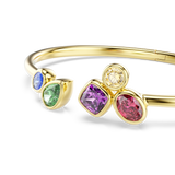 Gold-toned open bangle with a round blue and pear-shaped green stone on one end, and a square purple, round light yellow, and