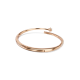 Rose gold-toned open bangle with a smooth band, a single clear crystal at one end, and a row of clear crystals on the other.