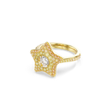Gold-toned ring with a star-shaped top covered in yellow and pinkish stones, featuring a larger clear stone in the center. Th