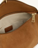 Tan faux suede shoulder bag with gold-toned zipper closure, light fabric lining, internal slip pocket, and visible stitching.