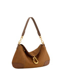 Brown faux suede shoulder bag with darker brown trim, gold-toned chain links, and a large gold-toned abstract pendant on the