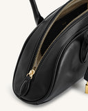 Black, structured shoulder bag with a rounded shape. Gold-toned top zipper, partially open, reveals light brown interior with