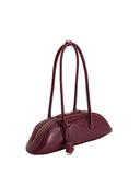 Deep claret smooth leather shoulder bag with an elongated, curved body, two thin straps, gold-toned top zipper, and tassel.