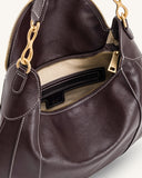 Dark brown shoulder bag with white contrast stitching, gold-toned zipper, and chain link detail. Light interior with pocket.