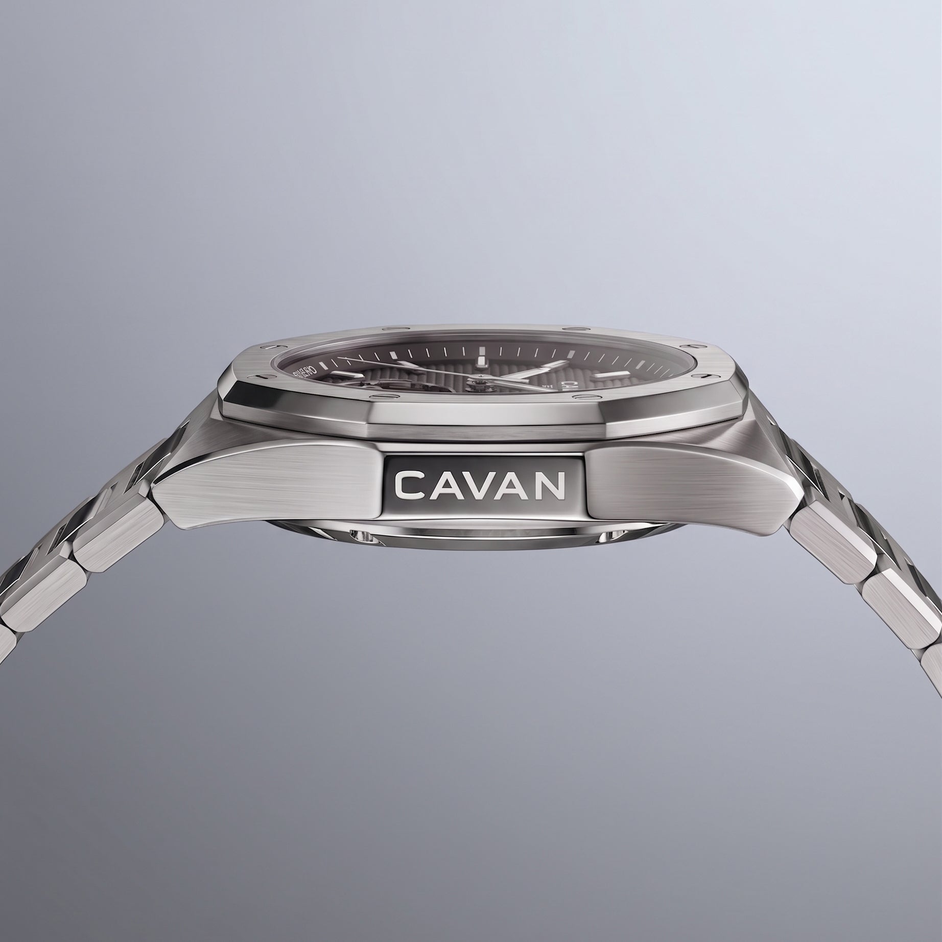 Silver-toned watch with octagonal bezel, dark grey textured dial, and integrated brushed metal bracelet. 'CAVAN' on case side