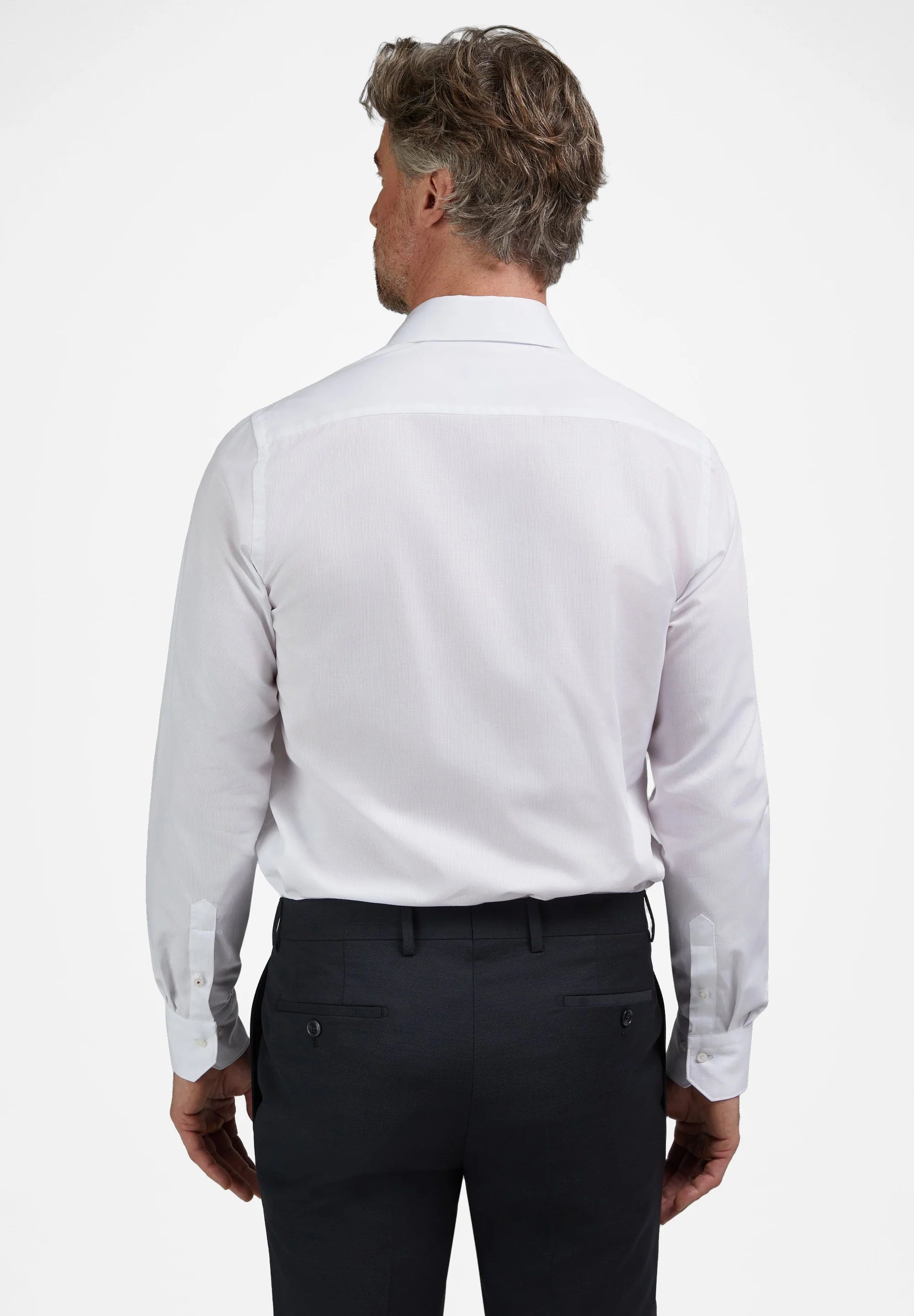 White long-sleeved dress shirt with a subtle vertical texture, featuring a collar, back yoke, and buttoned cuffs with two but