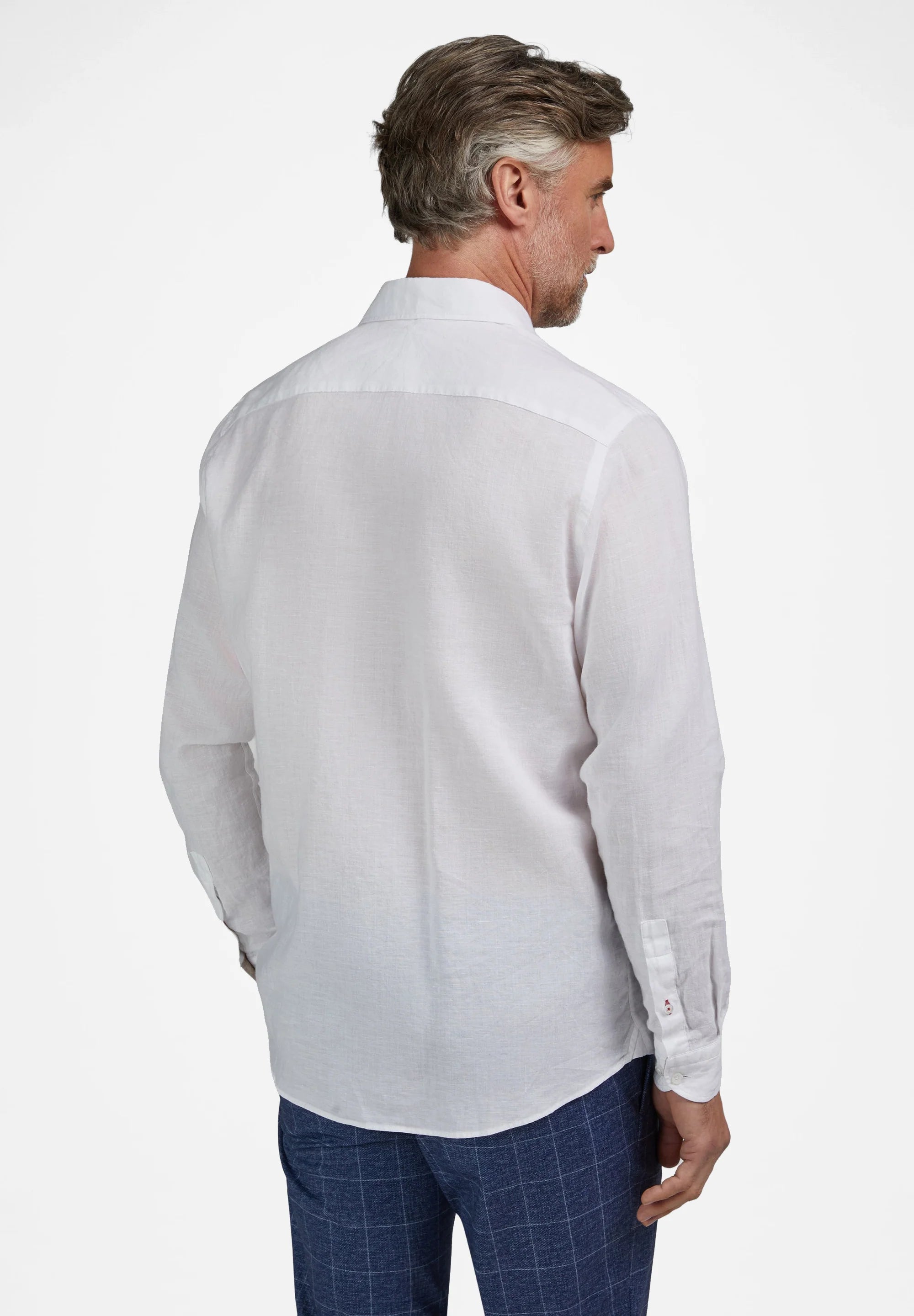 Textured white long-sleeved collared shirt with a back yoke and curved hem. The right cuff features two small red embroidered