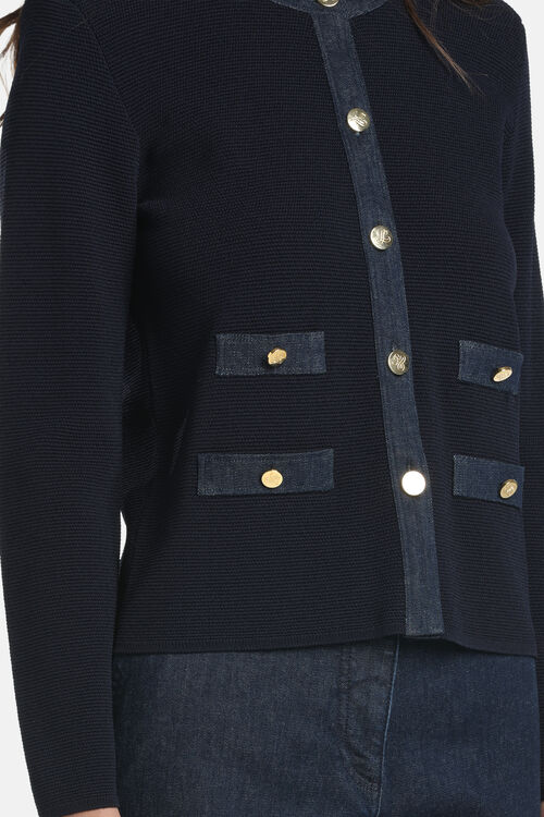 Dark blue ribbed knit cardigan with a denim button placket and four denim patch pockets, each with a gold-toned button.