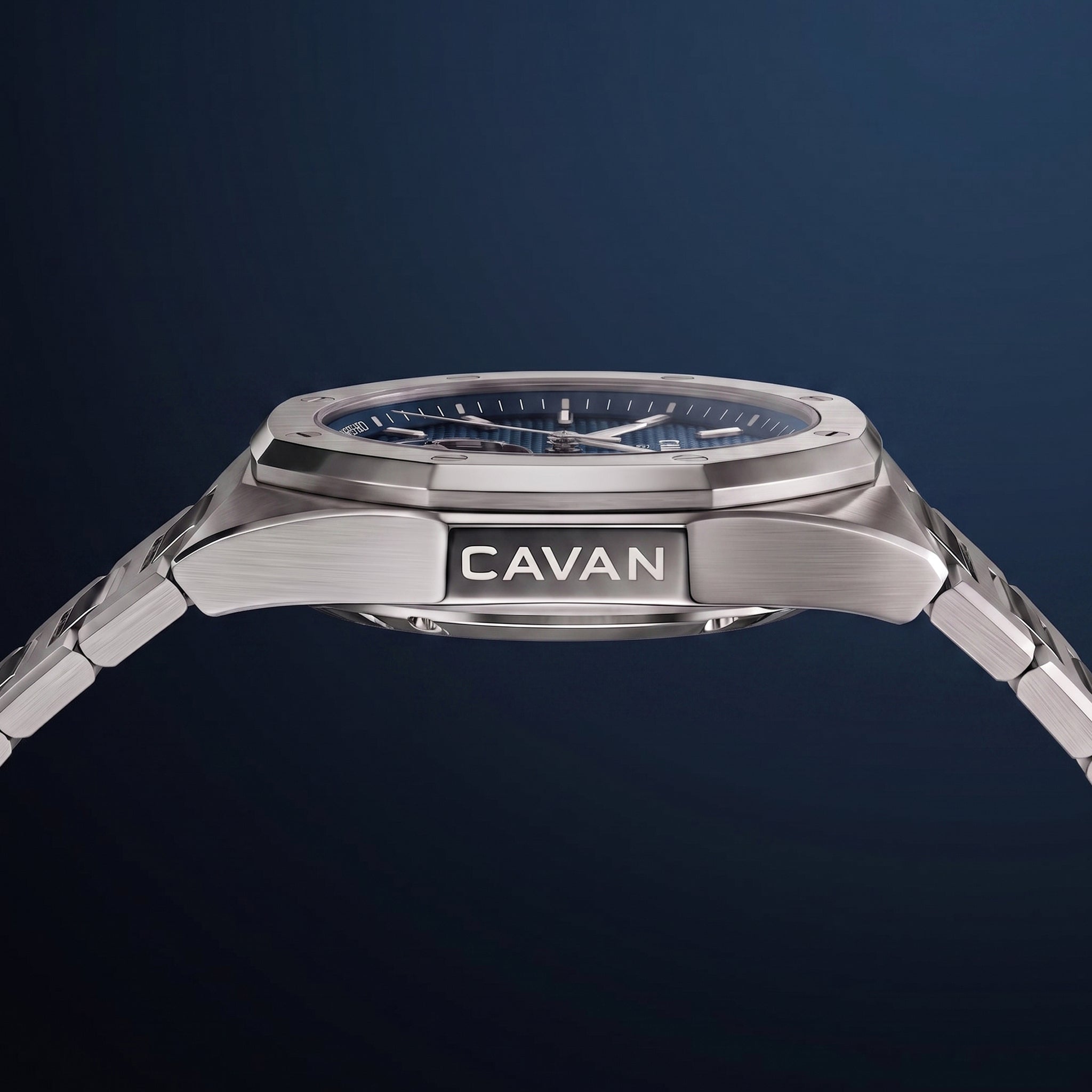Silver-toned watch with an octagonal bezel, blue textured dial with markers and date, and integrated metal bracelet. 'CAVAN'