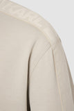 Light khaki zip jacket with subtle ribbing. A lighter khaki logo tape with embossed 'KARL LAGERFELD' text runs along the shou