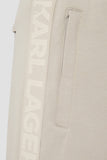 Khaki sweatpants with a vertical side logo tape featuring tone-on-tone 'KARL LAGERFELD' text and a zippered side pocket.