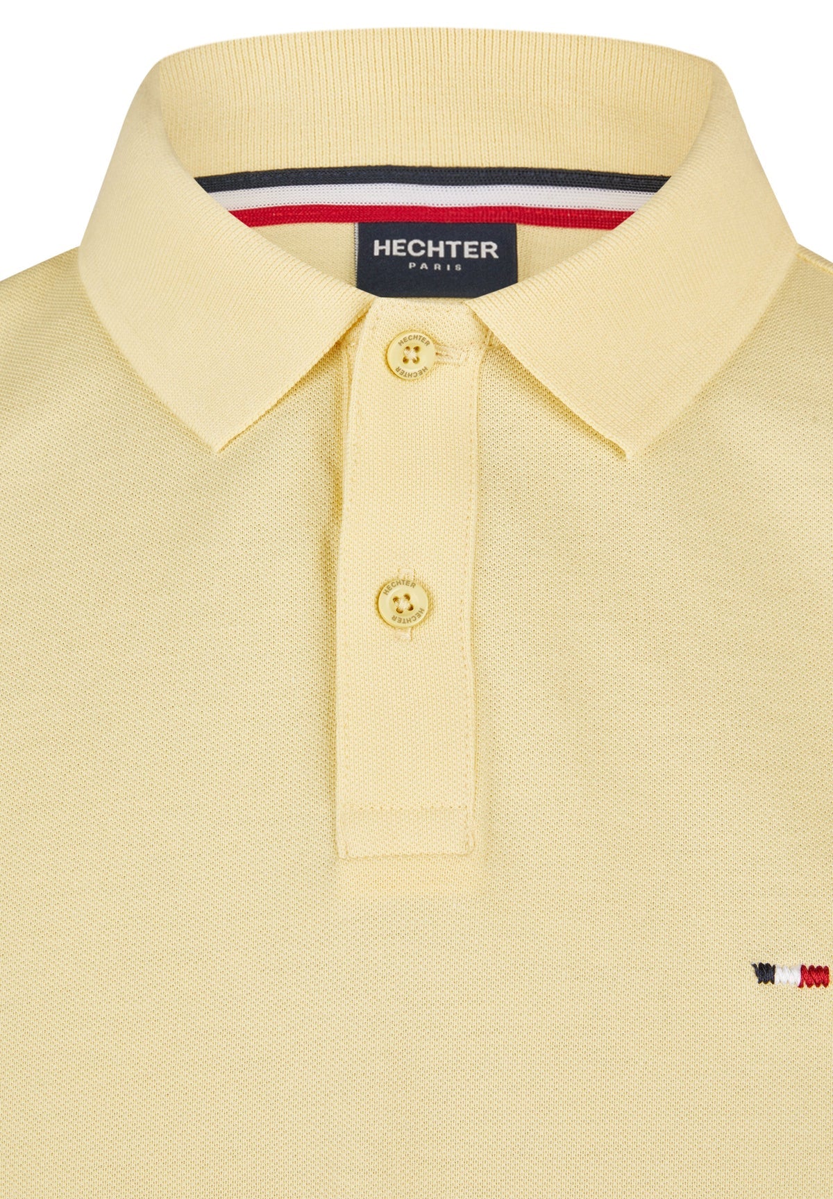 Vanilla pique knit polo shirt with a two-button placket, light yellow buttons, and a small embroidered red, white, and blue l
