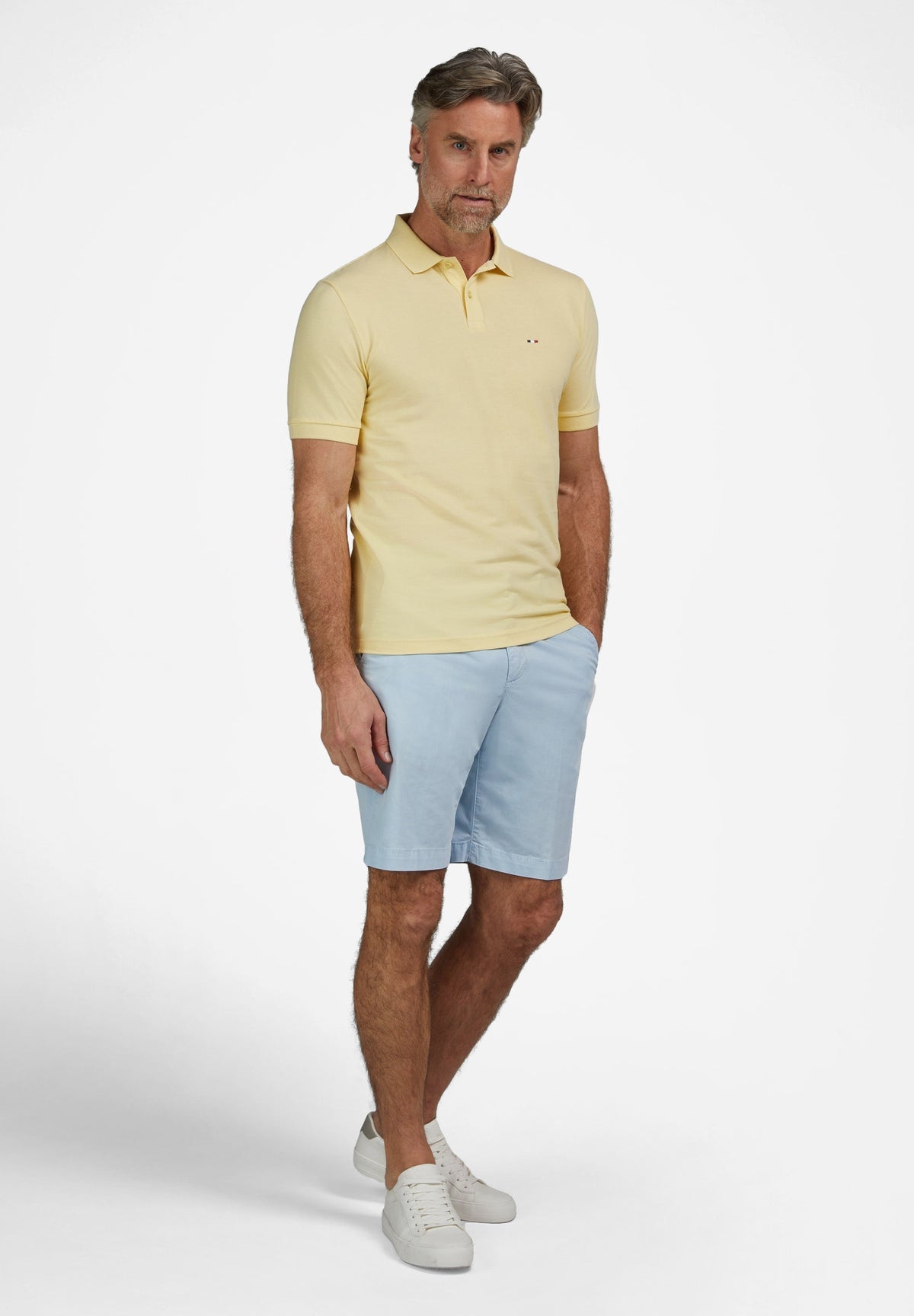 Vanilla pique knit short-sleeved polo shirt with a classic collar, two-button placket, and a small red and blue dot logo on t